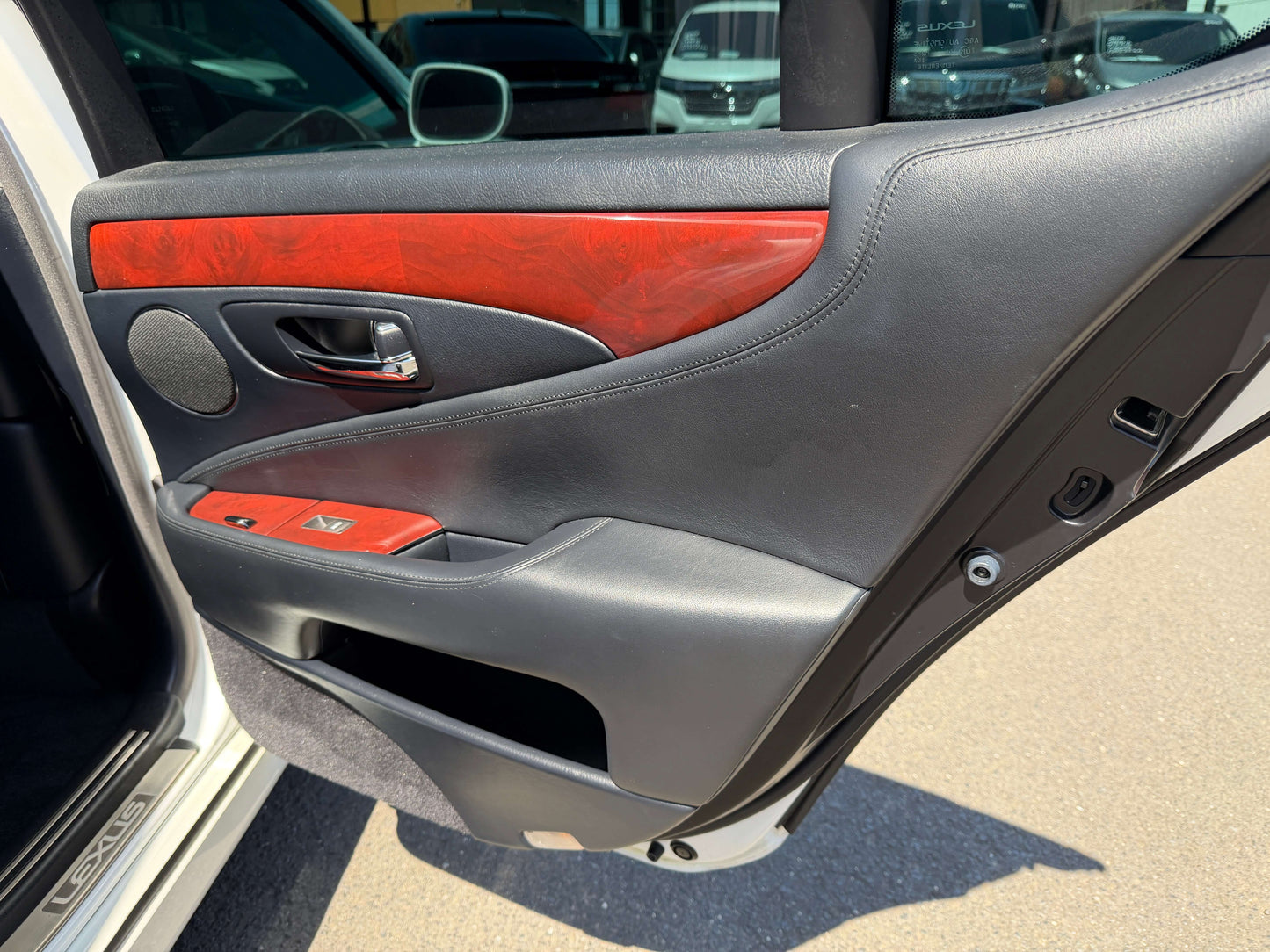 Luxury interior door panel of 2007 Lexus LS600h AWD V8 5.0L Hybrid, featuring wood accents and modern design.