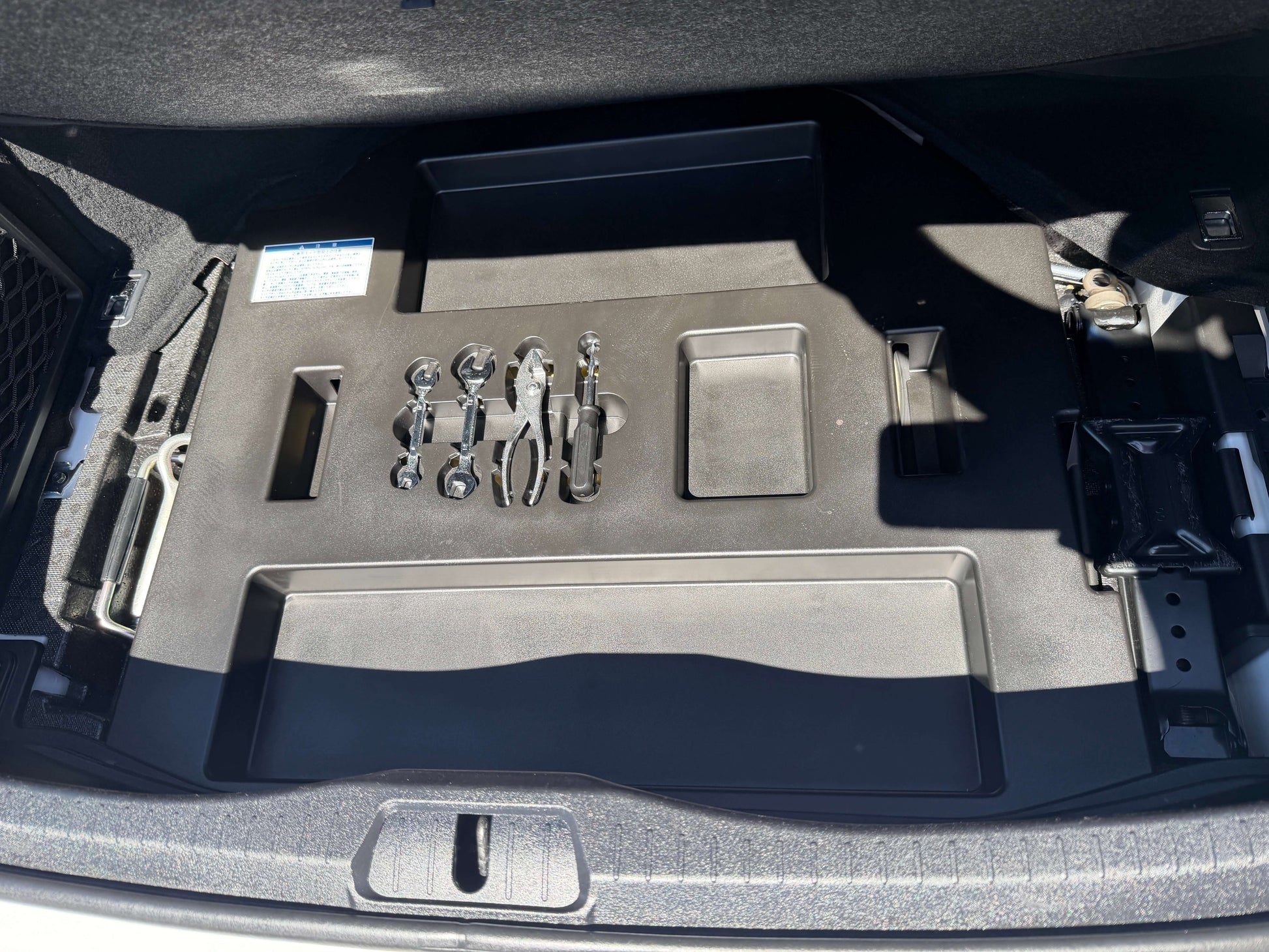 Storage compartment in the trunk of a 2007 Lexus LS600h AWD V8 5.0L Hybrid, showing tools and organization features.