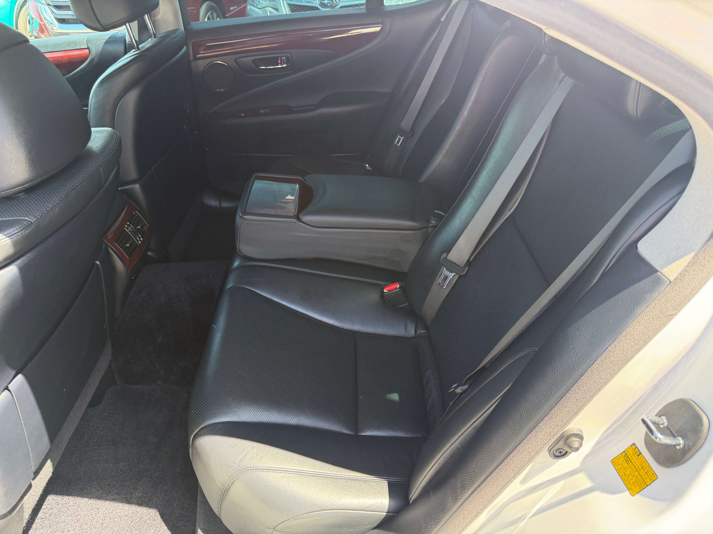 Interior view of the back seats in 2007 Lexus LS600h AWD V8 5.0L Hybrid Luxury Sedan, showcasing black leather upholstery.