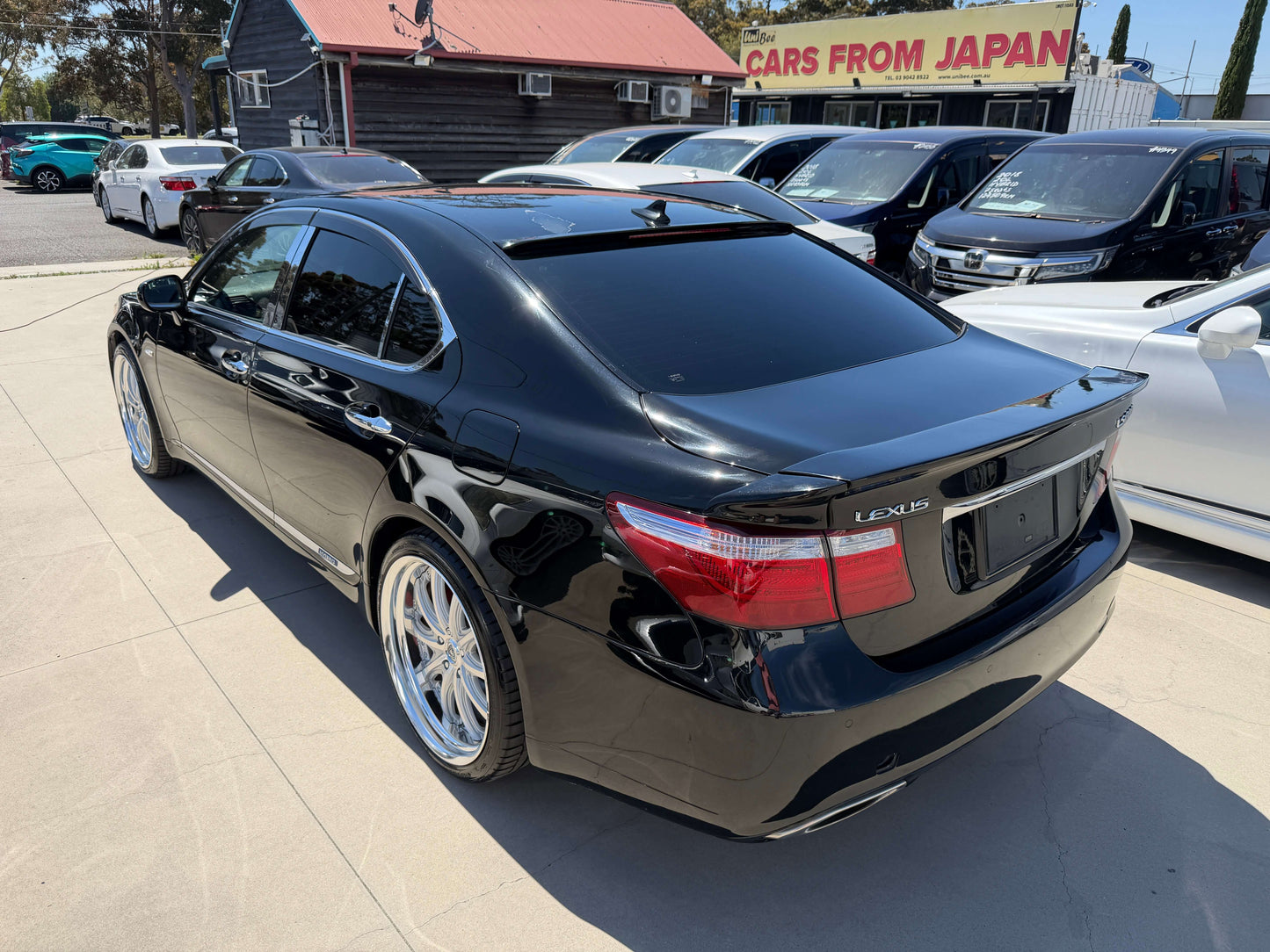 2007 Lexus LS600h AWD V8 5.0L Hybrid luxury sedan in black parked outdoors with shiny wheels.