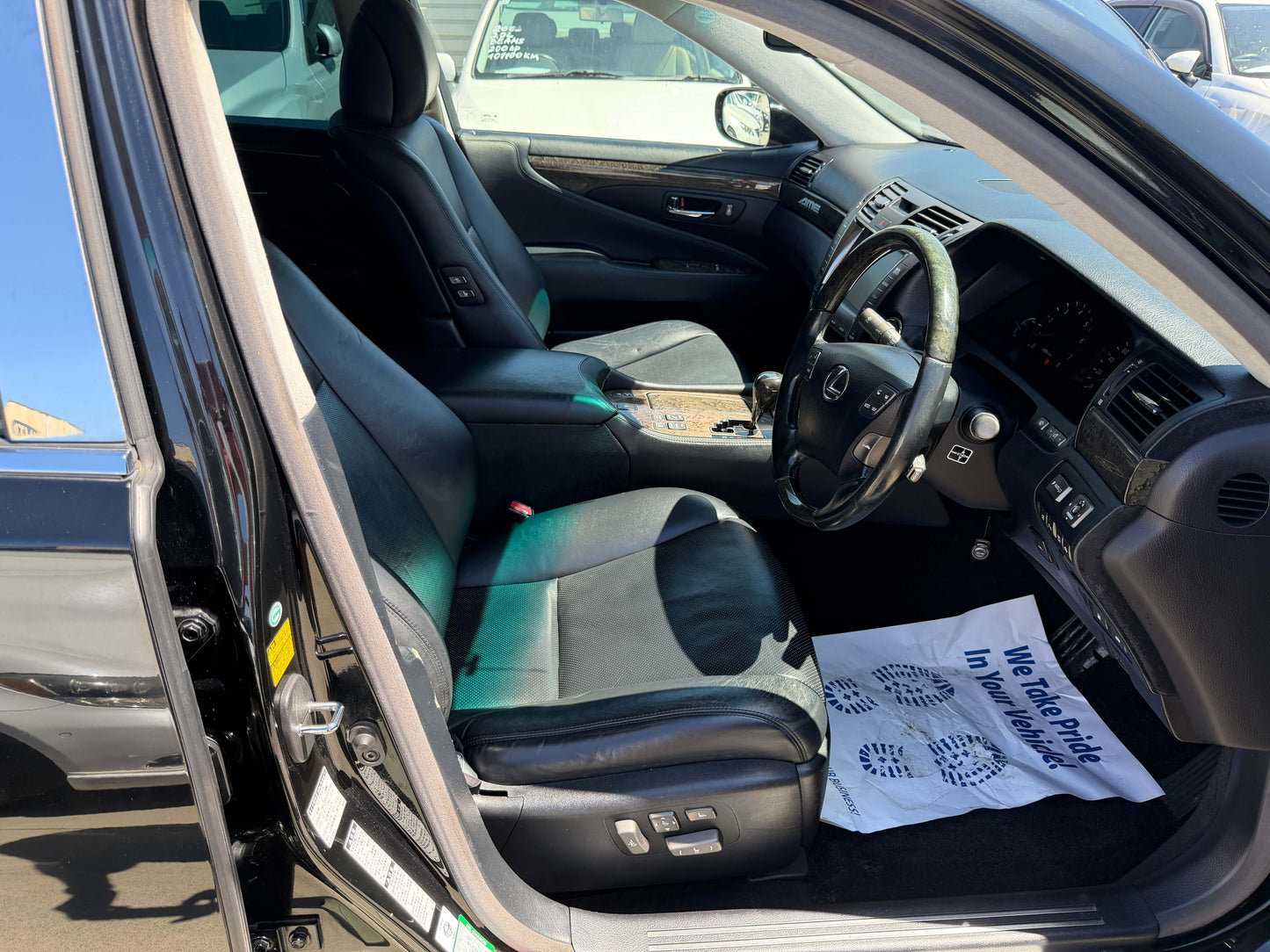 Interior view of a 2007 Lexus LS600h AWD V8 5.0L Hybrid Luxury Sedan, showcasing leather seats and dashboard.