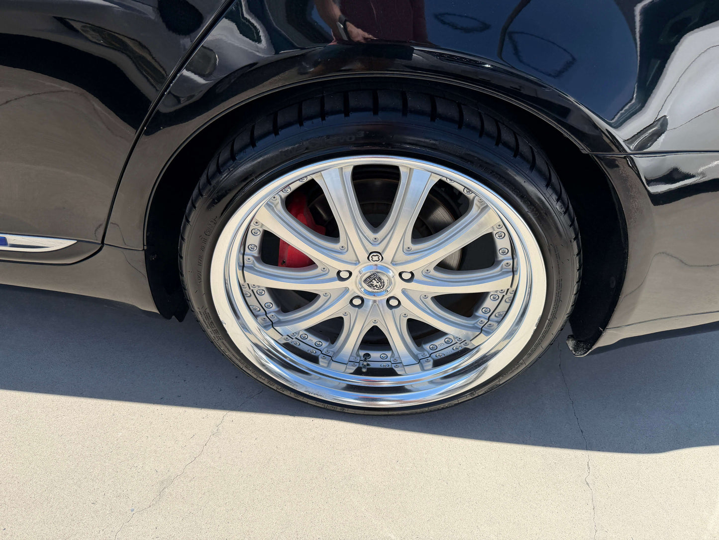 Close-up of a chrome alloy wheel on a black 2007 Lexus LS600h AWD V8 5.0L Hybrid luxury sedan.