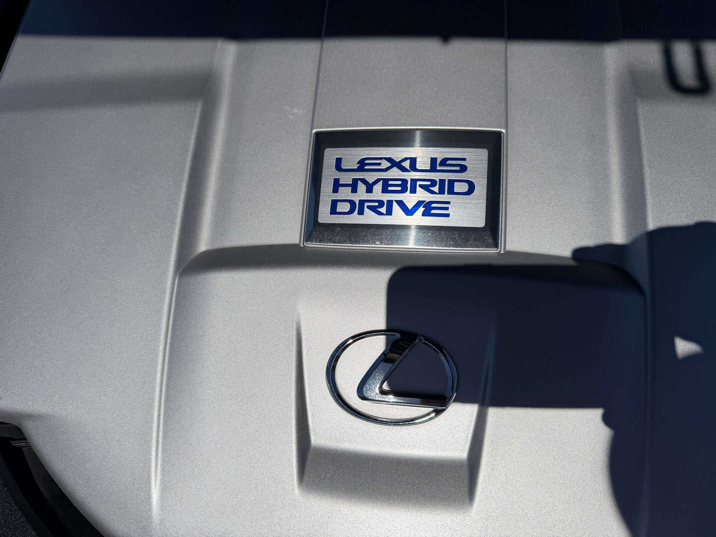 Close-up of Lexus Hybrid Drive badge on engine cover of a 2007 Lexus LS600h AWD V8 5.0L Hybrid luxury sedan.