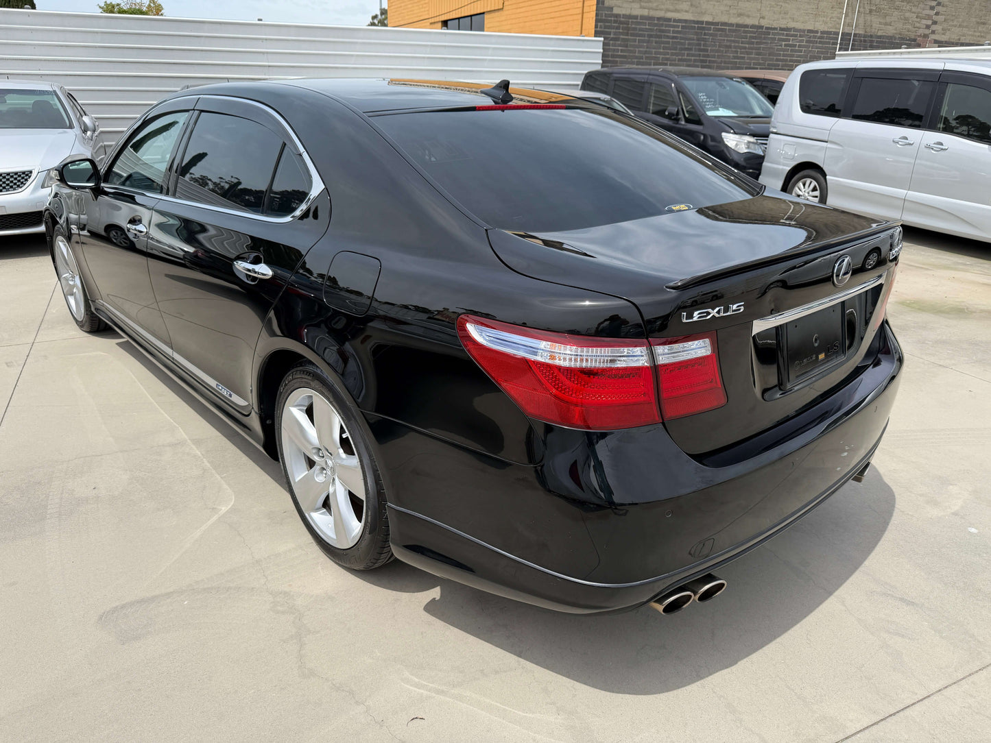 2007 Lexus LS600hL AWD V8 5.0L Hybrid luxury sedan parked in a lot with a sleek black exterior and tinted windows.