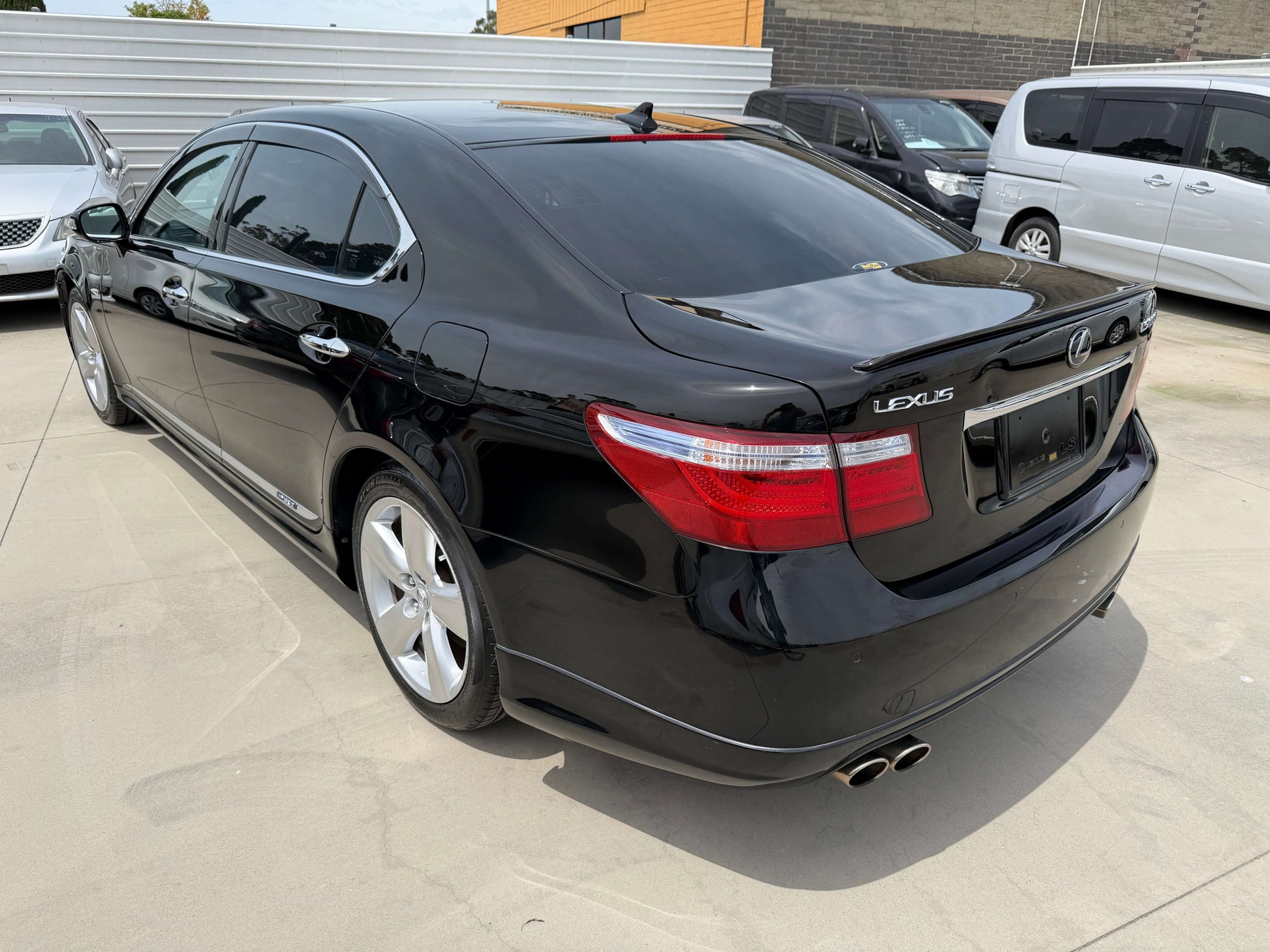 2007 Lexus LS600hL AWD V8 5.0L Hybrid luxury sedan parked in a lot with a sleek black exterior and tinted windows.