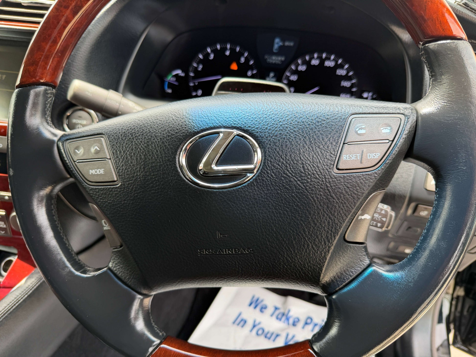 2007 Lexus LS600hL AWD V8 5.0L Hybrid steering wheel with controls and wood accents.