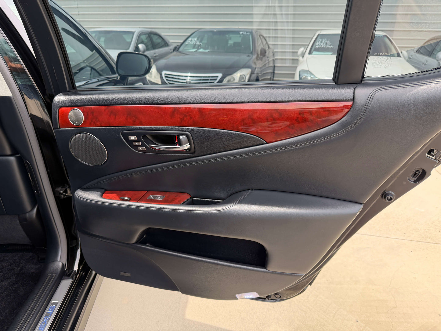 Interior door panel of 2007 Lexus LS600hL AWD V8 5.0L Hybrid, showcasing luxury features and wood accents.