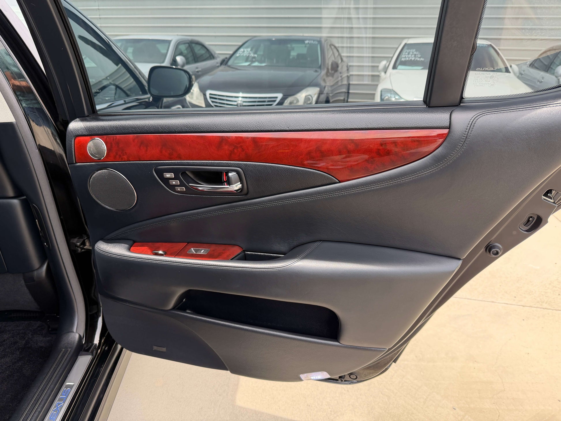 Interior door panel of 2007 Lexus LS600hL AWD V8 5.0L Hybrid, showcasing luxury features and wood accents.