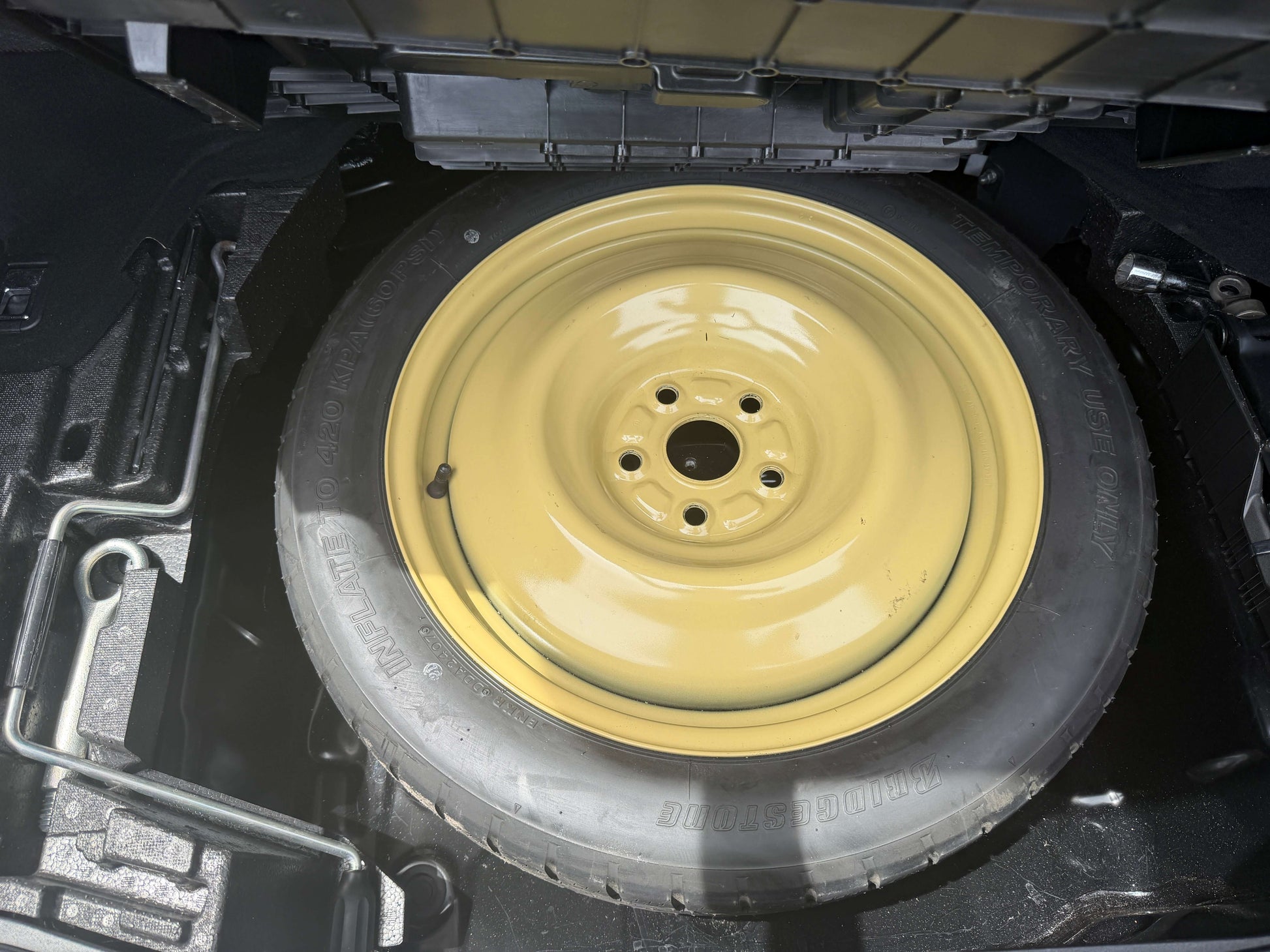 Spare tire of a 2007 Lexus LS600hL AWD V8 5.0L Hybrid luxury sedan under the trunk compartment.