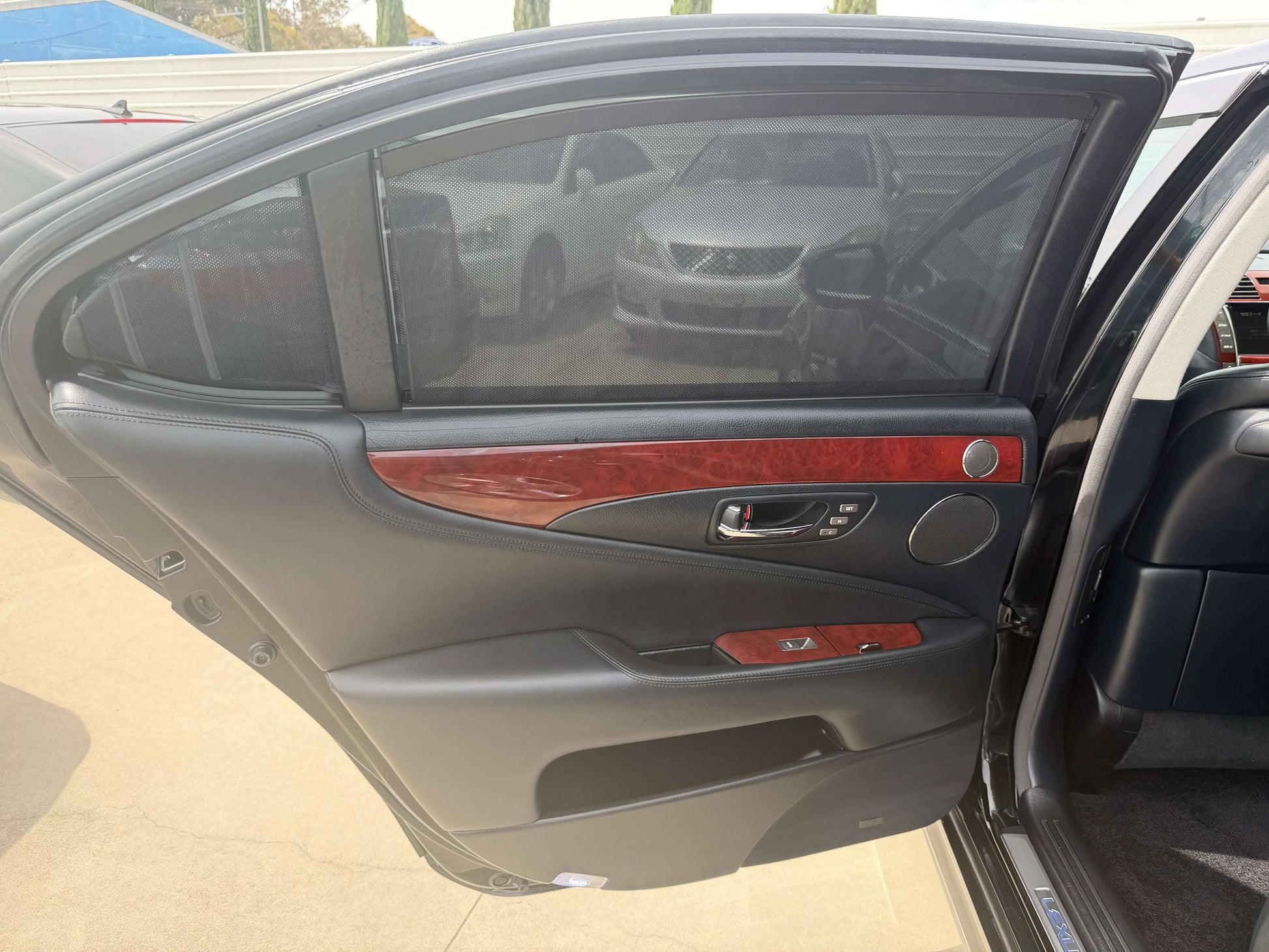 Interior view of the 2007 Lexus LS600hL AWD V8 5.0L Hybrid luxury sedan rear door with wood trim and privacy screens.