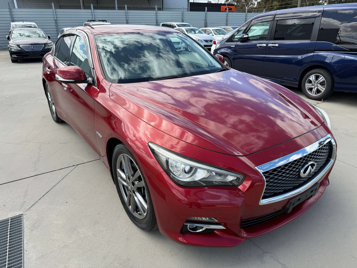 2015 Nissan Skyline V6 3.5L Hybrid Sport Sedan in deep red with stylish design and sleek lines.