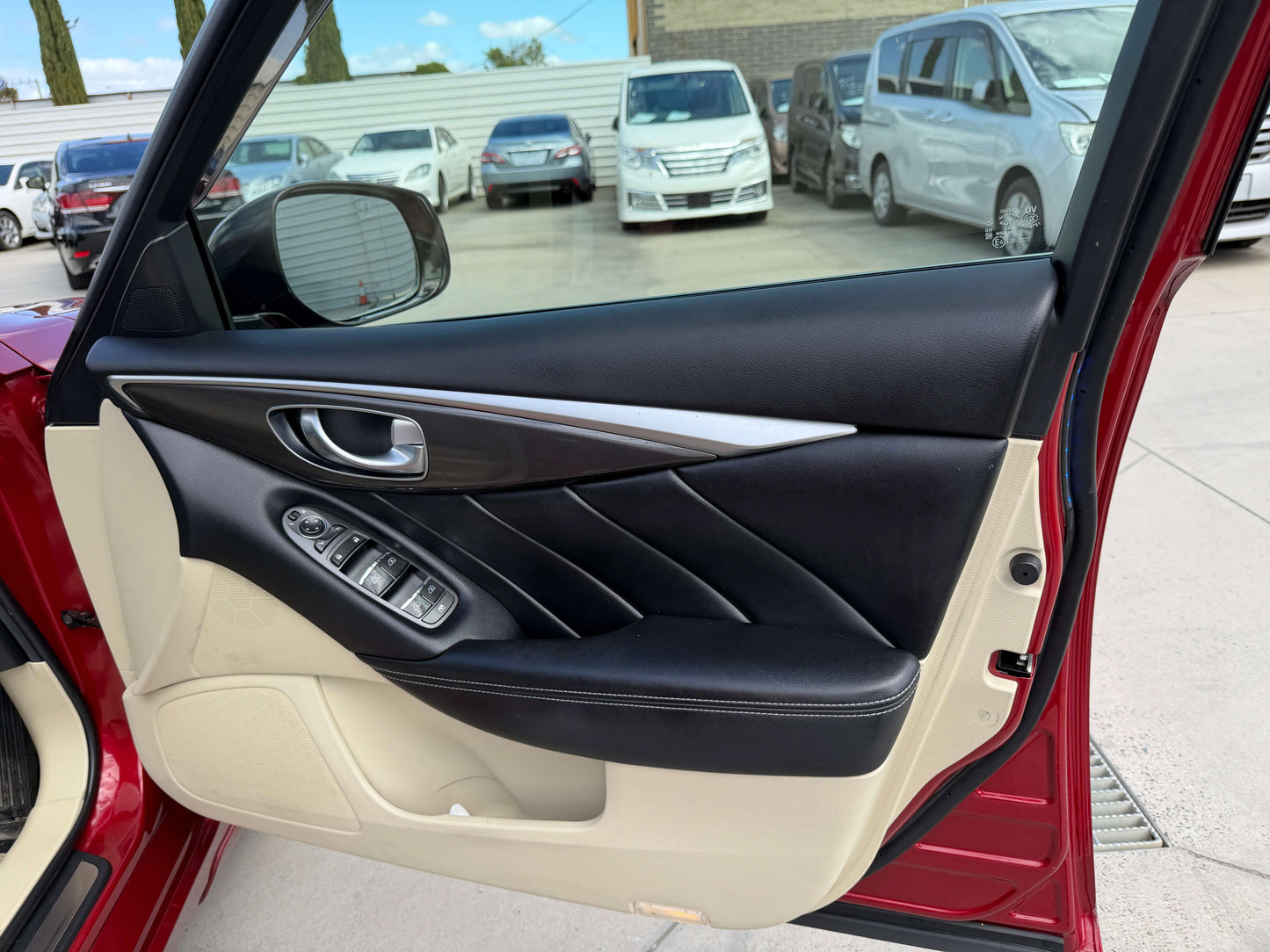 Interior door panel of a 2015 Nissan Skyline V6 3.5L Hybrid showing modern design and controls.