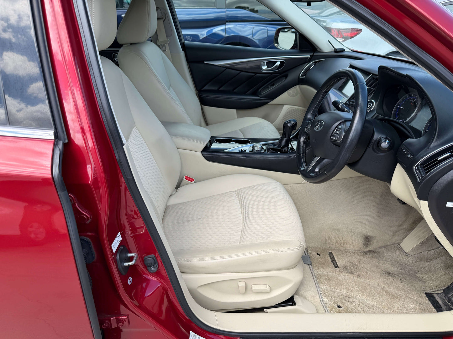 Interior view of the 2015 Nissan Skyline V6 3.5L Hybrid showcasing beige upholstery and modern dashboard features.