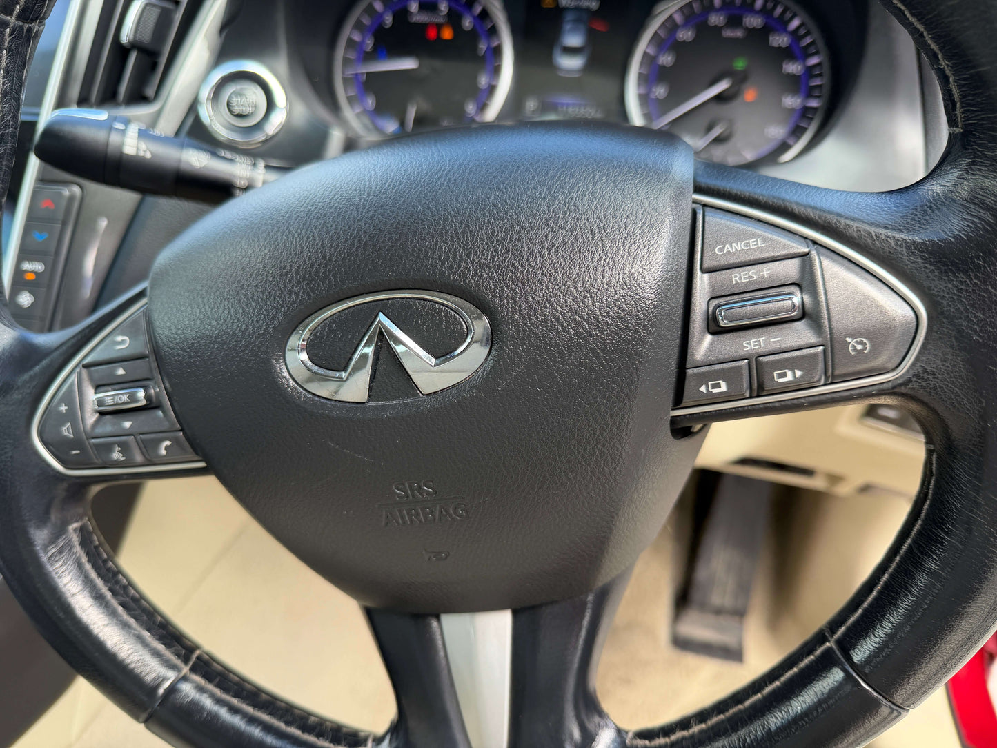 Interior view of the steering wheel featuring the logo of the 2015 Nissan Skyline V6 3.5L Hybrid 350GT Sport Sedan.