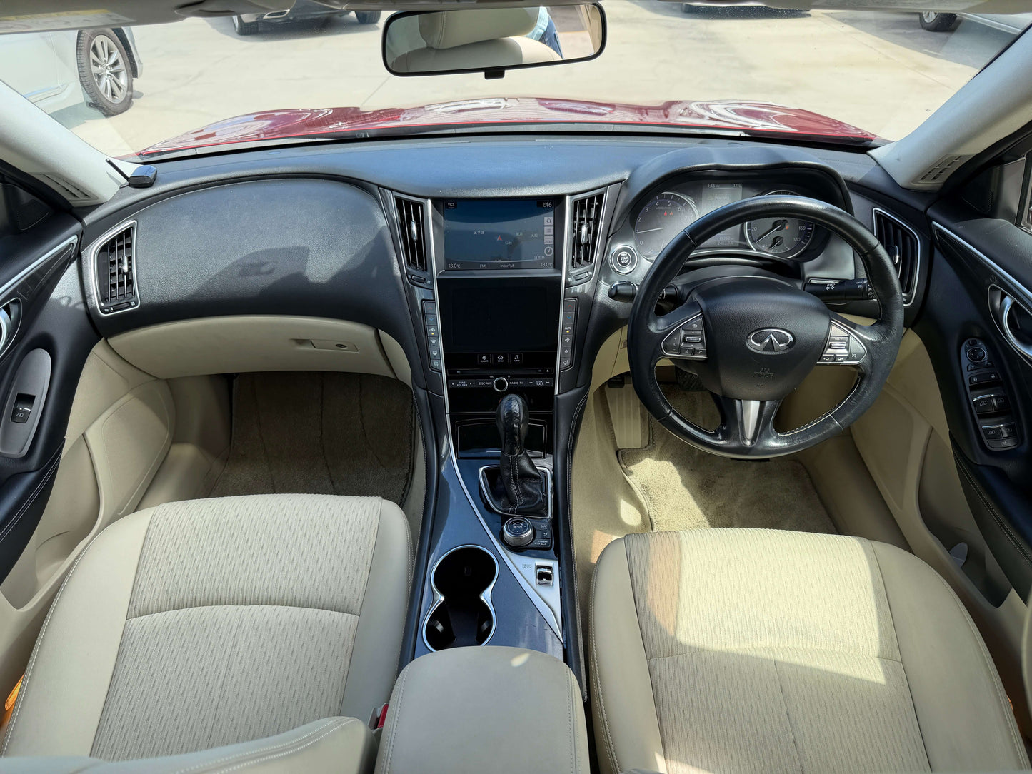 Interior view of 2015 Nissan Skyline V6 3.5L Hybrid showing beige upholstery and modern dashboard design.