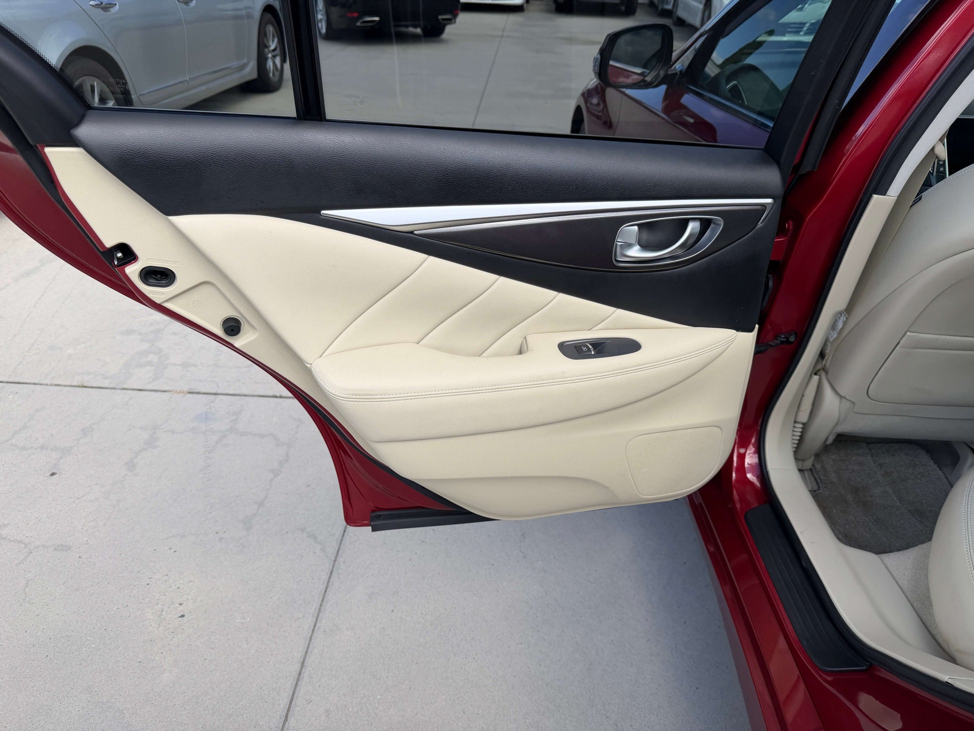 Interior view of the 2015 Nissan Skyline V6 3.5L Hybrid door featuring beige leather panels.