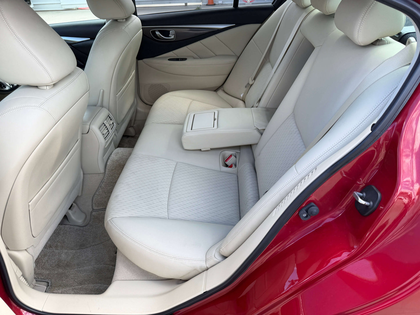 2015 Nissan Skyline V6 3.5L Hybrid rear interior seating view, featuring beige leather upholstery and spacious design.