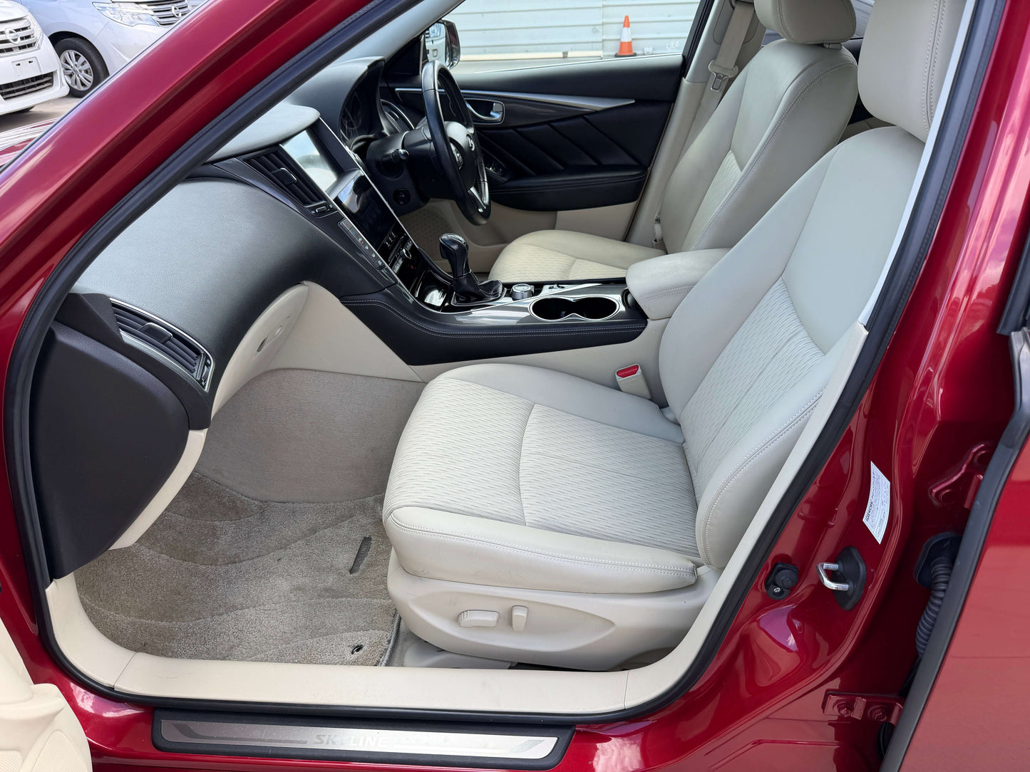 Interior view of the 2015 Nissan Skyline V6 3.5L Hybrid, showcasing beige seats and modern dashboard.