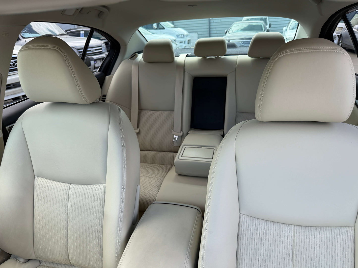 Interior view of 2015 Nissan Skyline V6 3.5L Hybrid with beige seats, spacious rear seating area.