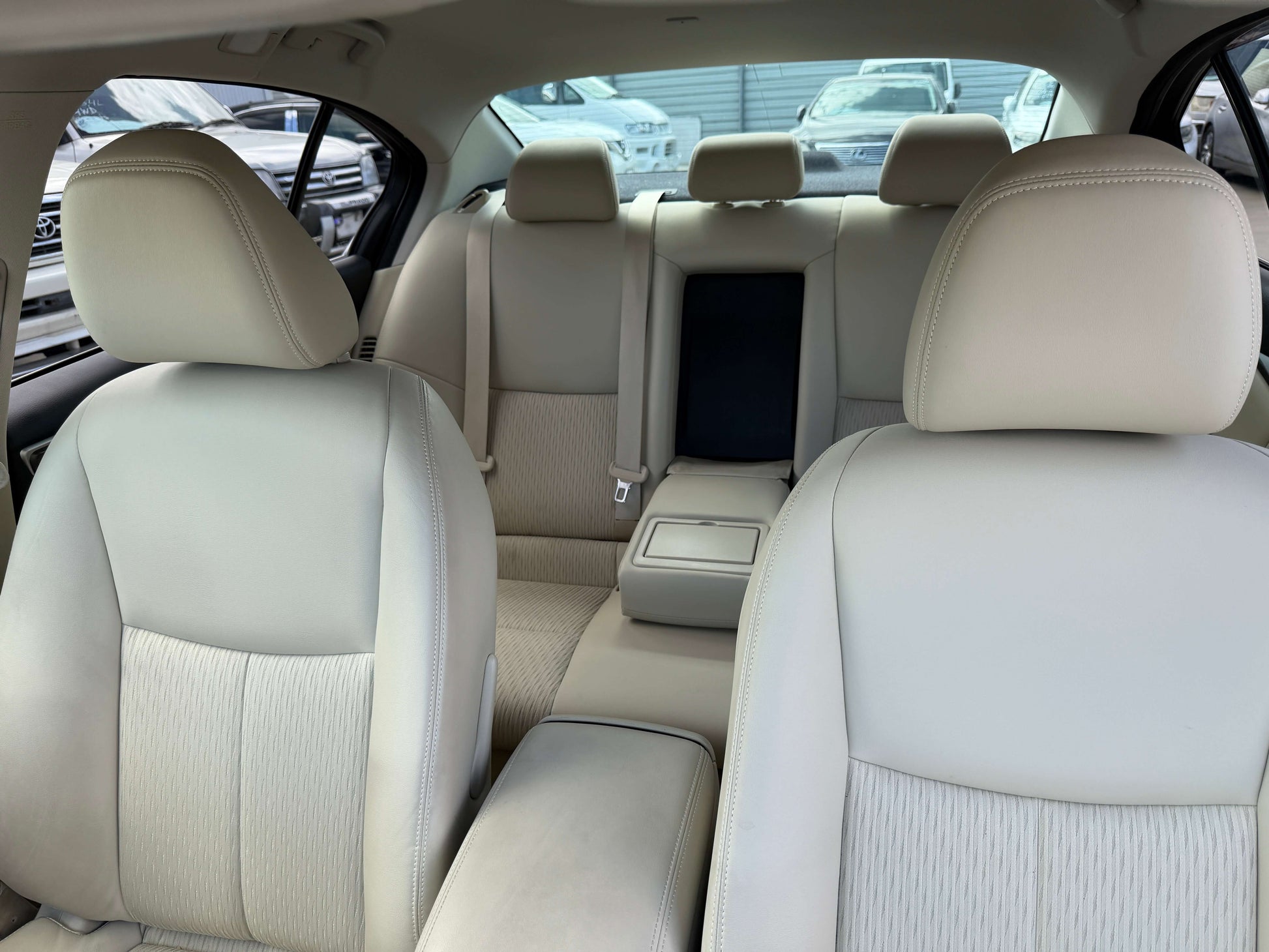 Interior view of 2015 Nissan Skyline V6 3.5L Hybrid with beige seats, spacious rear seating area.