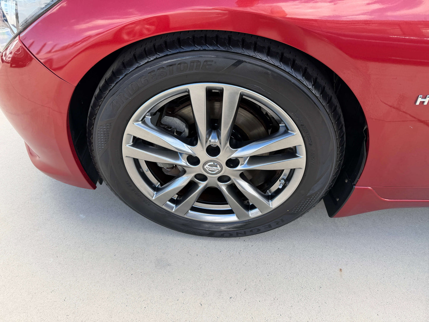 2015 Nissan Skyline V6 3.5L Hybrid wheel and tire close-up showcasing sporty alloy design.