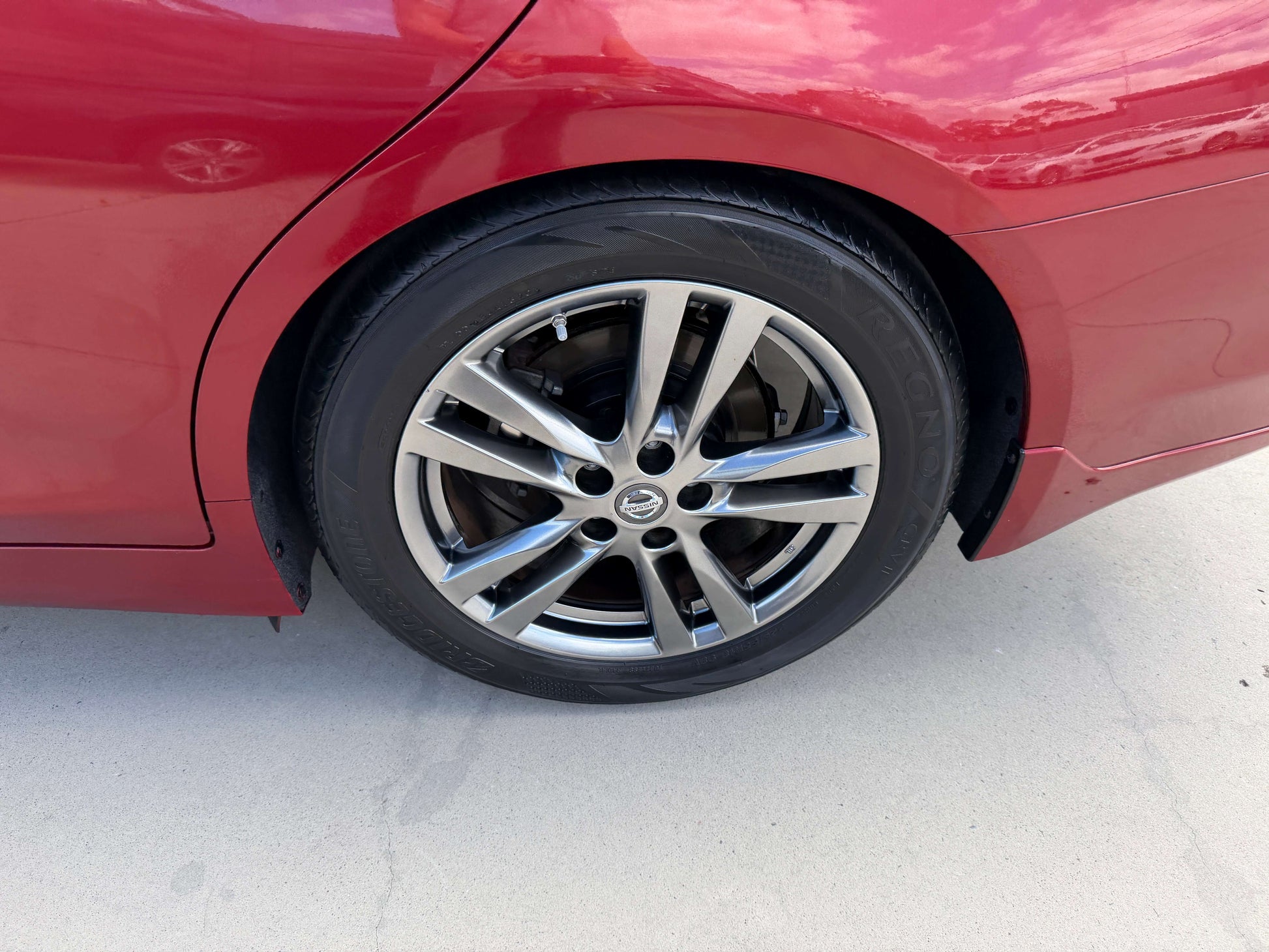 Close-up view of the wheel of a 2015 Nissan Skyline V6 3.5L Hybrid, showcasing its sporty alloy design.