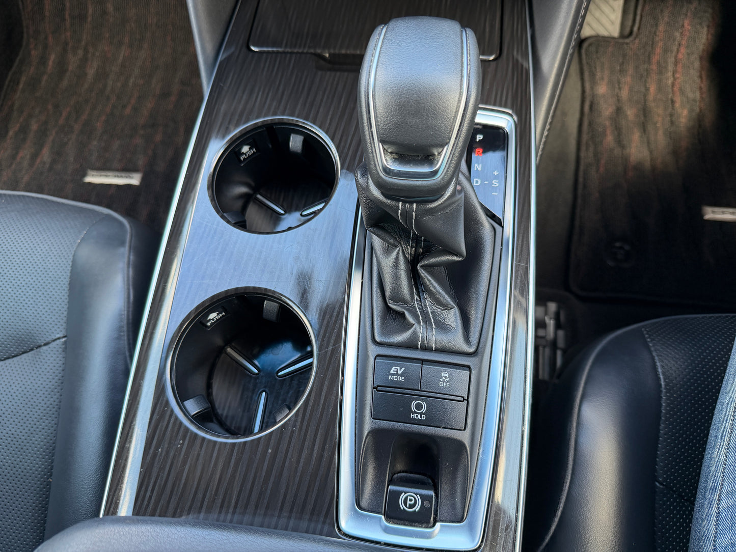 Interior console of the 2019 Toyota Crown 2.5L Hybrid showing gear shift and cup holders.