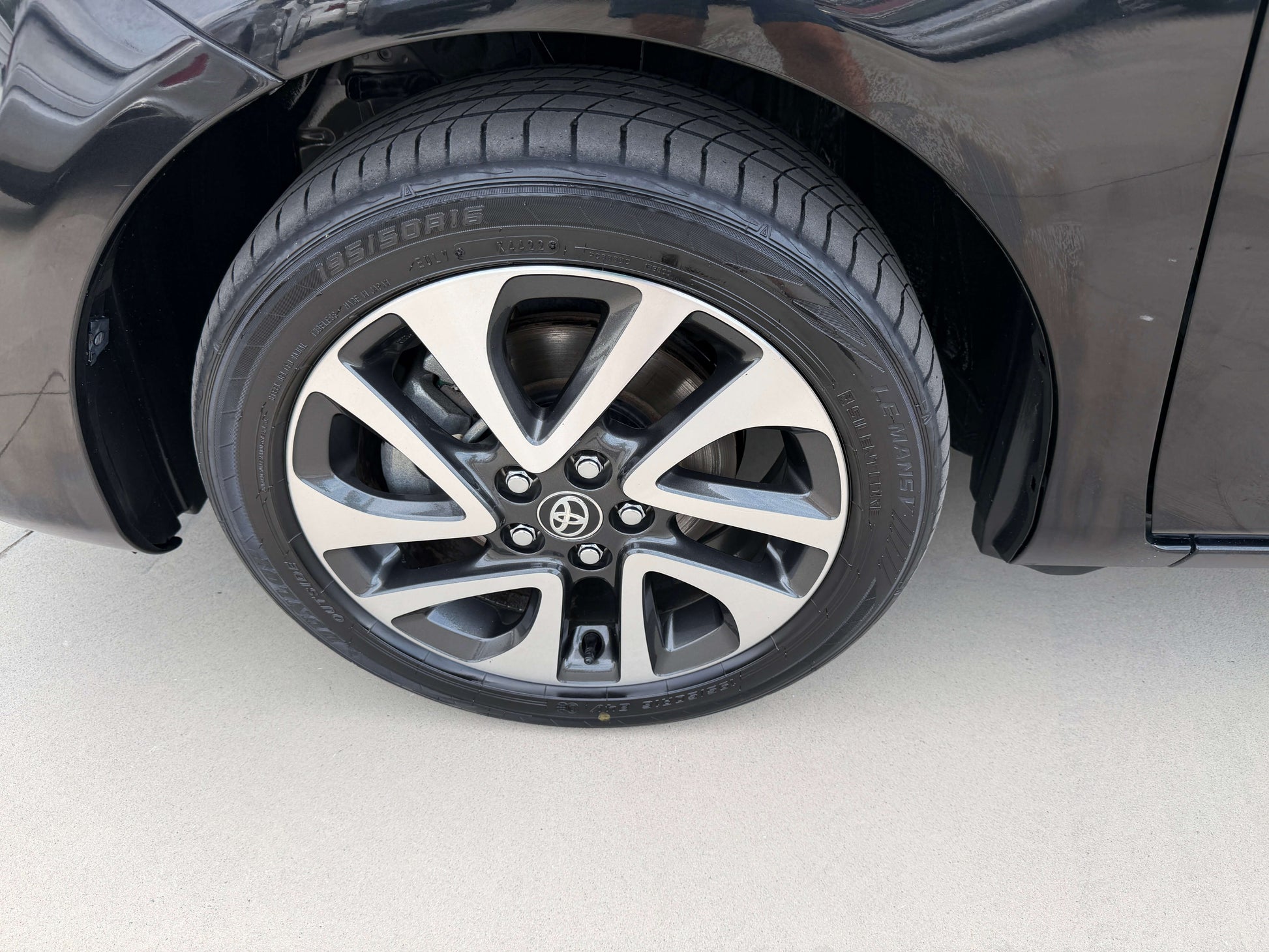 Close-up of the alloy wheel of a 2018 Toyota Sienta 1.5L Hybrid showcasing design and tread details.