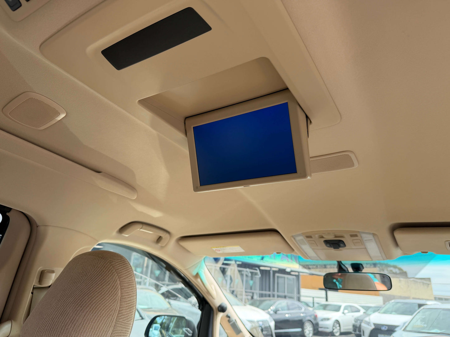 Interior view of the 2010 Toyota Vellfire 2.4L featuring a drop-down screen installed in the ceiling.