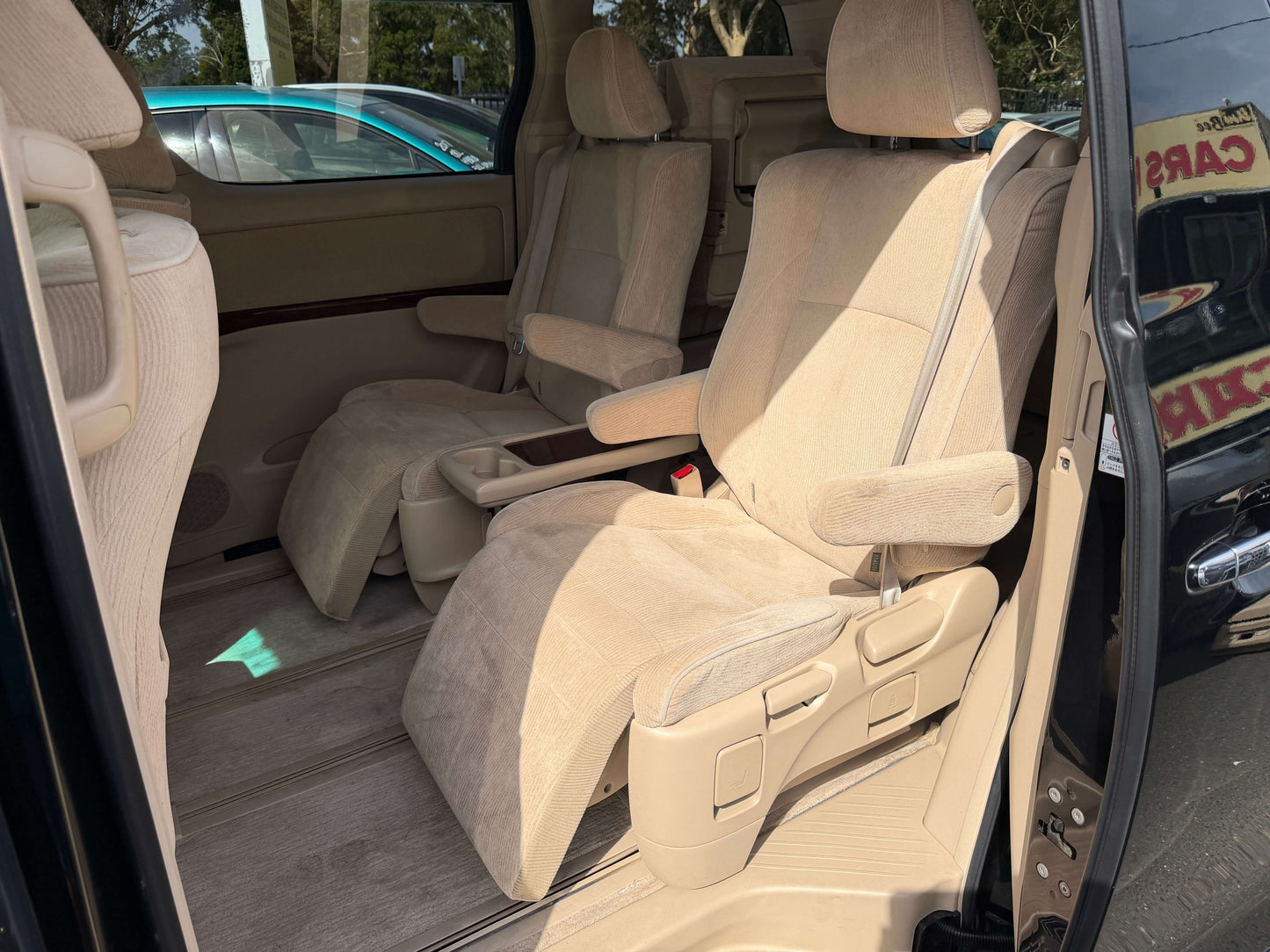 Interior of a 2010 Toyota Vellfire 2.4L showcasing spacious beige seating and comfortable layout.