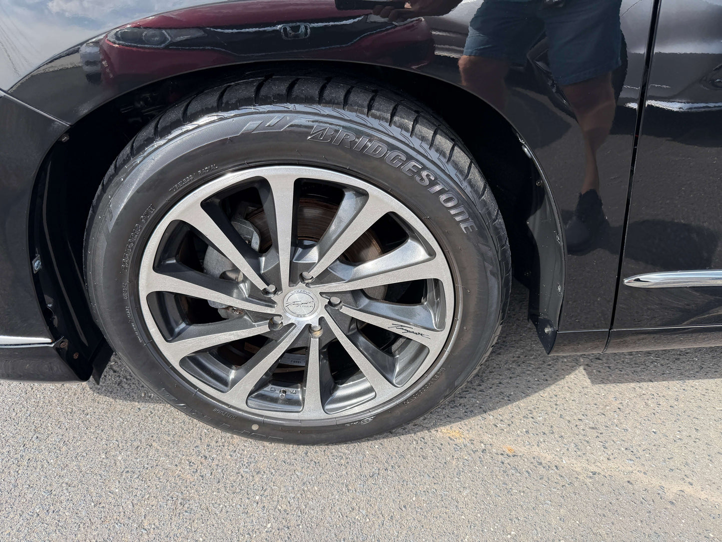 Close-up of the stylish alloy wheel on a 2010 Toyota Vellfire 2.4L V Edition, showcasing its premium design and Bridgestone tire.