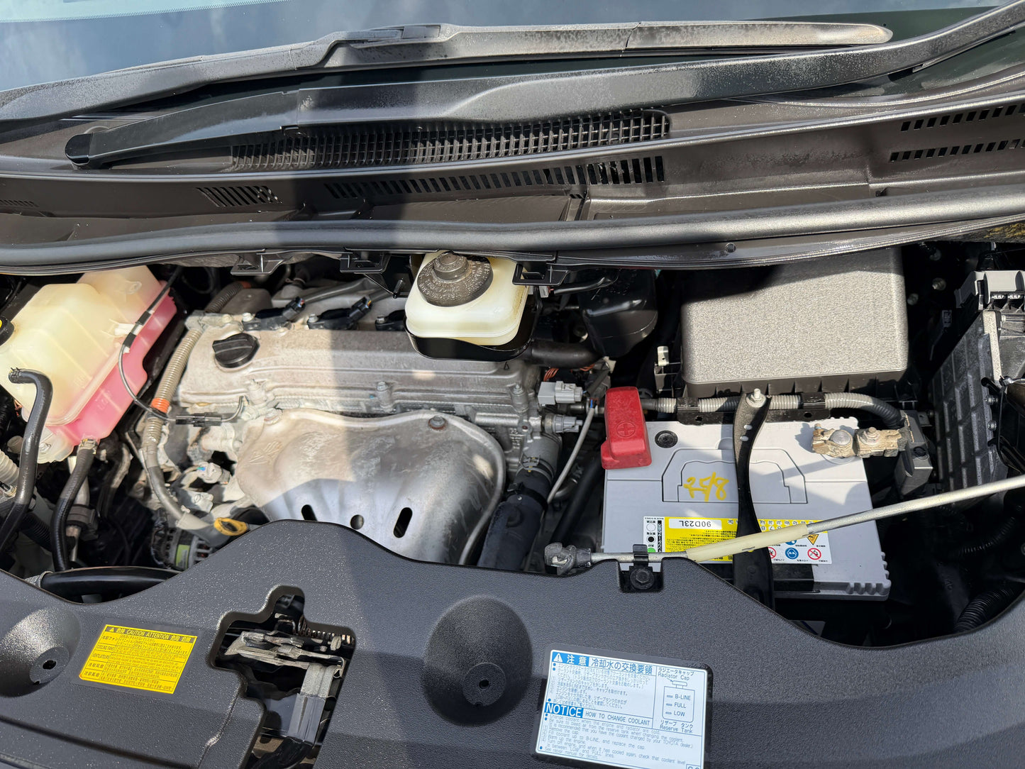 Engine compartment of a 2010 Toyota Vellfire 2.4L showing battery and key components.