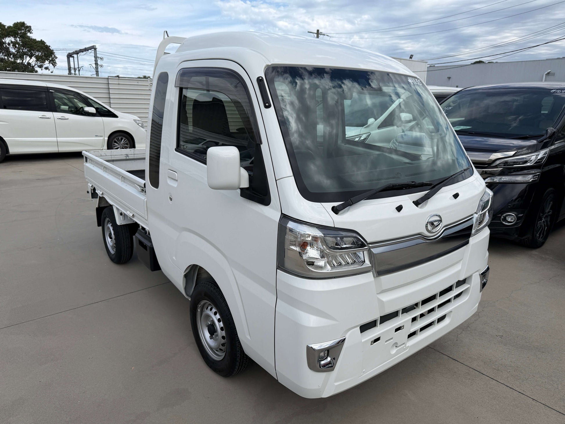2021 Daihatsu Hijet Truck 660 Jumbo SA IIIt parked in an outdoor setting, featuring a white exterior and two seats.