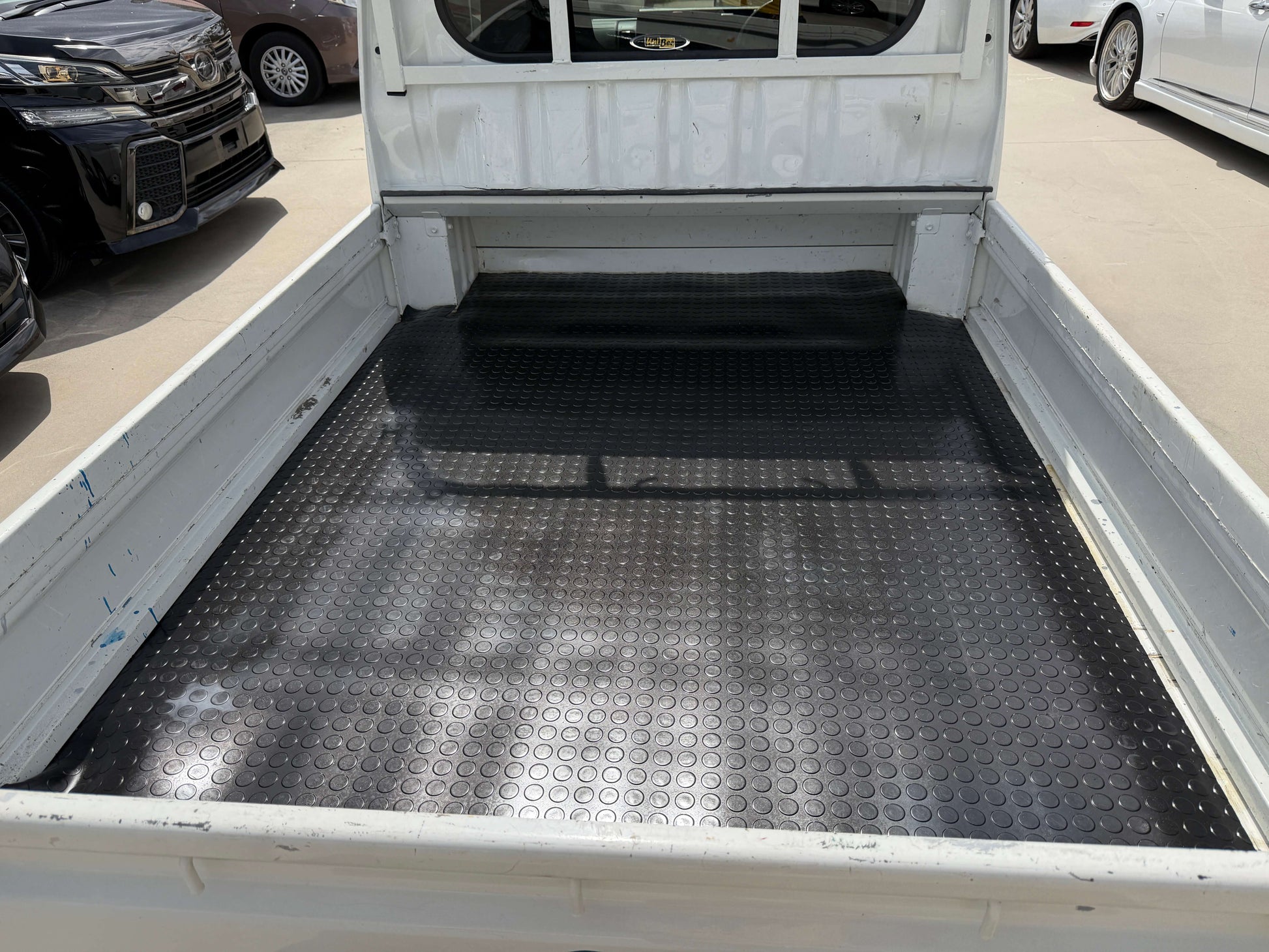 Interior view of a 2021 Daihatsu Hijet Truck 660 Jumbo SA IIIt bed with black rubber flooring.