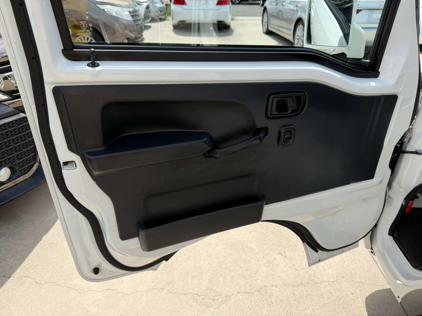 Interior door of 2021 Daihatsu Hijet Truck 660 Jumbo SA IIIt, showcasing door handle and controls.