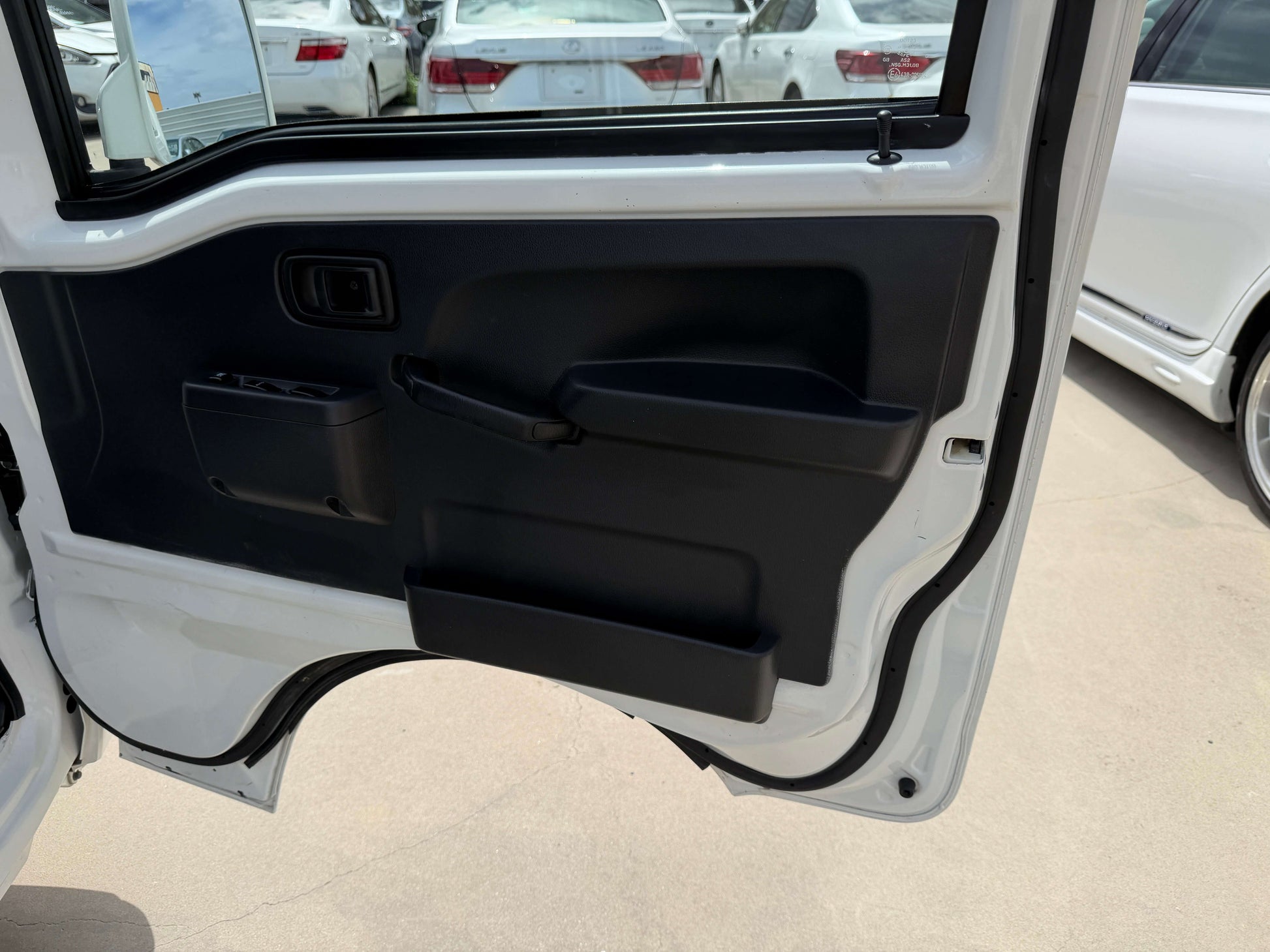 Interior view of the 2021 Daihatsu Hijet Truck 660 door panel with storage compartment.