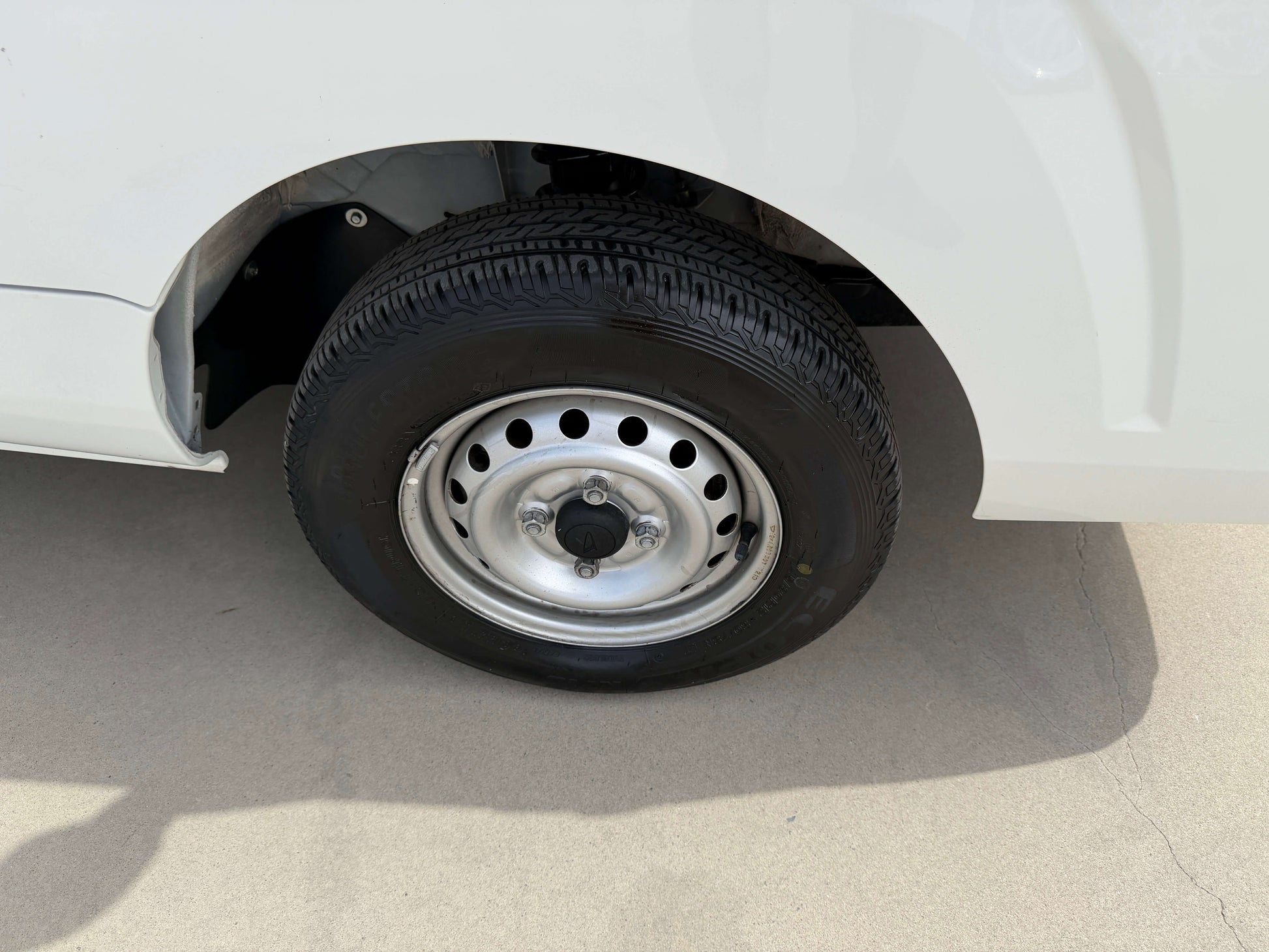 2021 Daihatsu Hijet Truck 660 wheel with chrome hubcap and black tire close-up