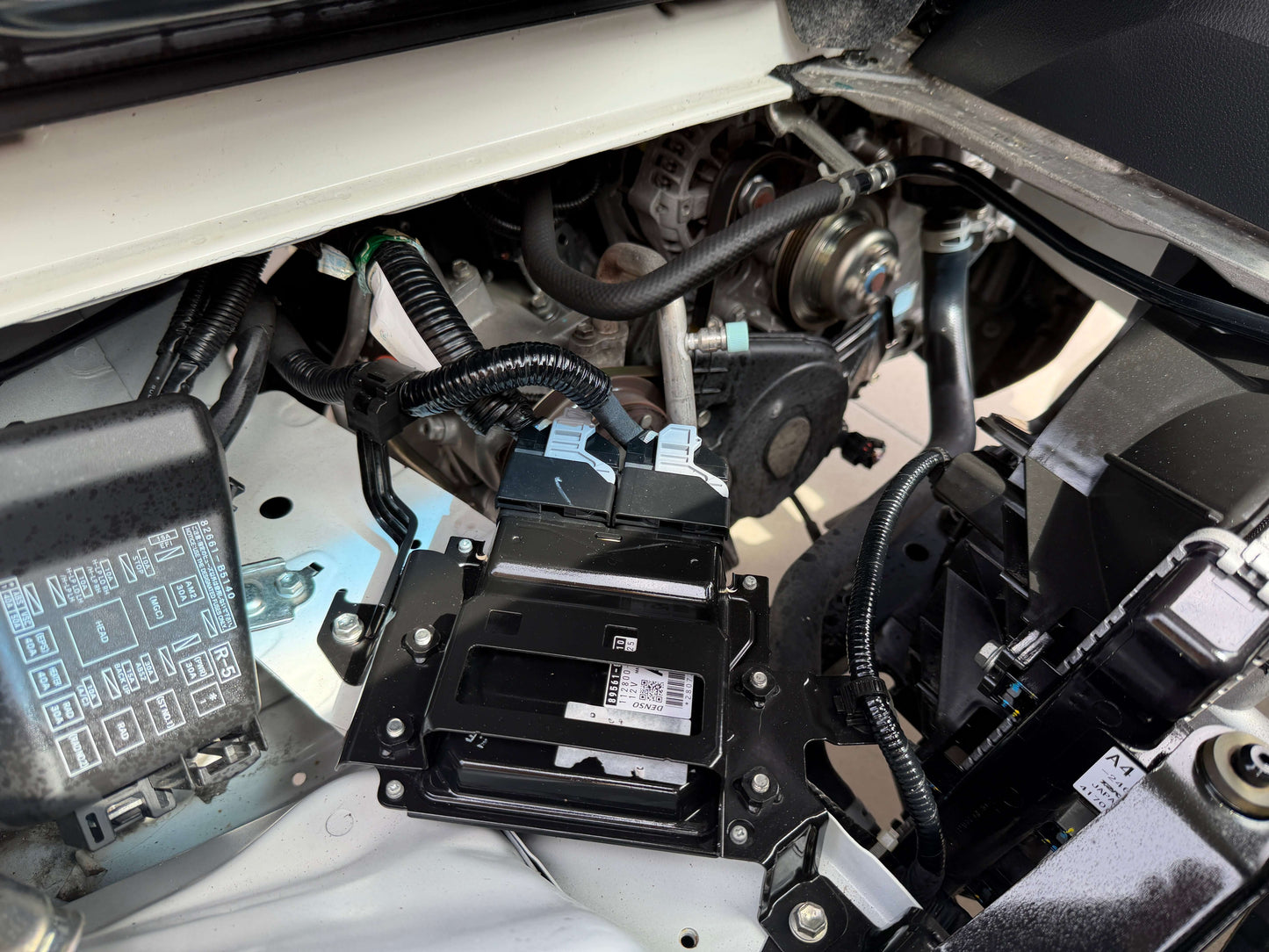 Close-up view of the engine compartment of a 2021 Daihatsu Hijet Truck 660 showing components and wiring.