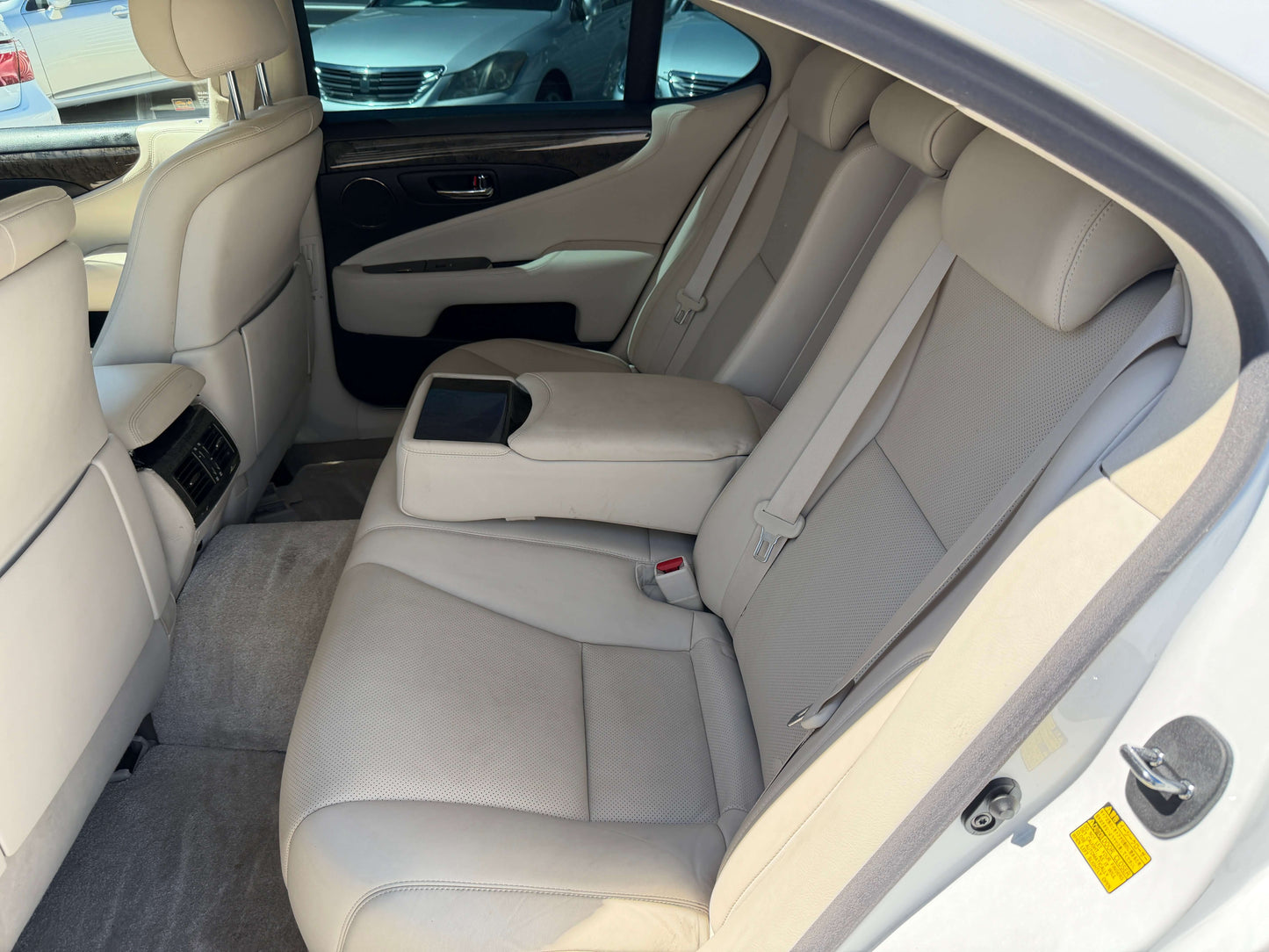 Interior view of 2007 Lexus LS600h AWD V8 5.0L Hybrid luxury sedan back seat with beige leather upholstery.