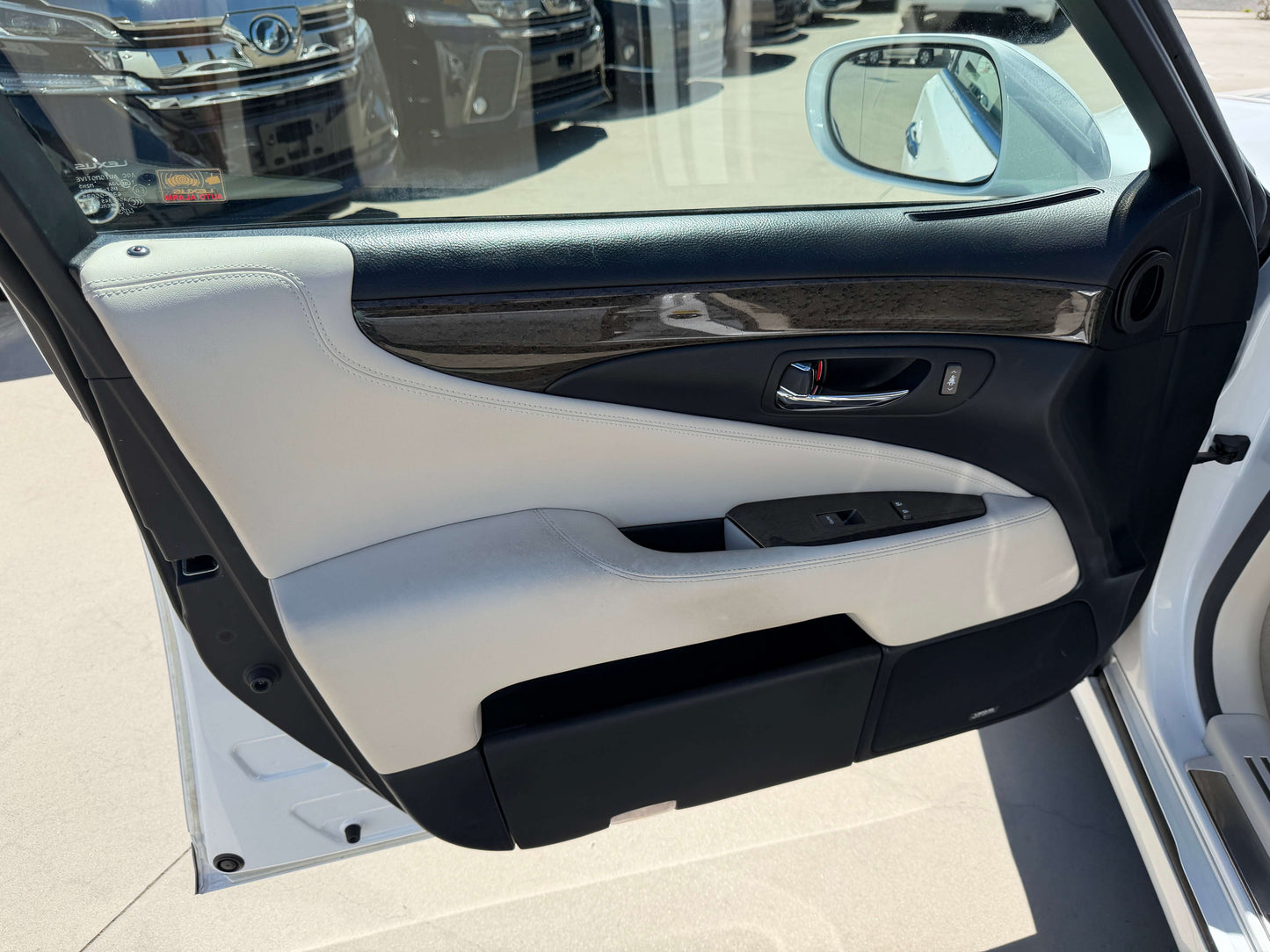 Interior view of the 2007 Lexus LS600h AWD V8 5.0L Hybrid luxury sedan door panel with leather and wood accents.