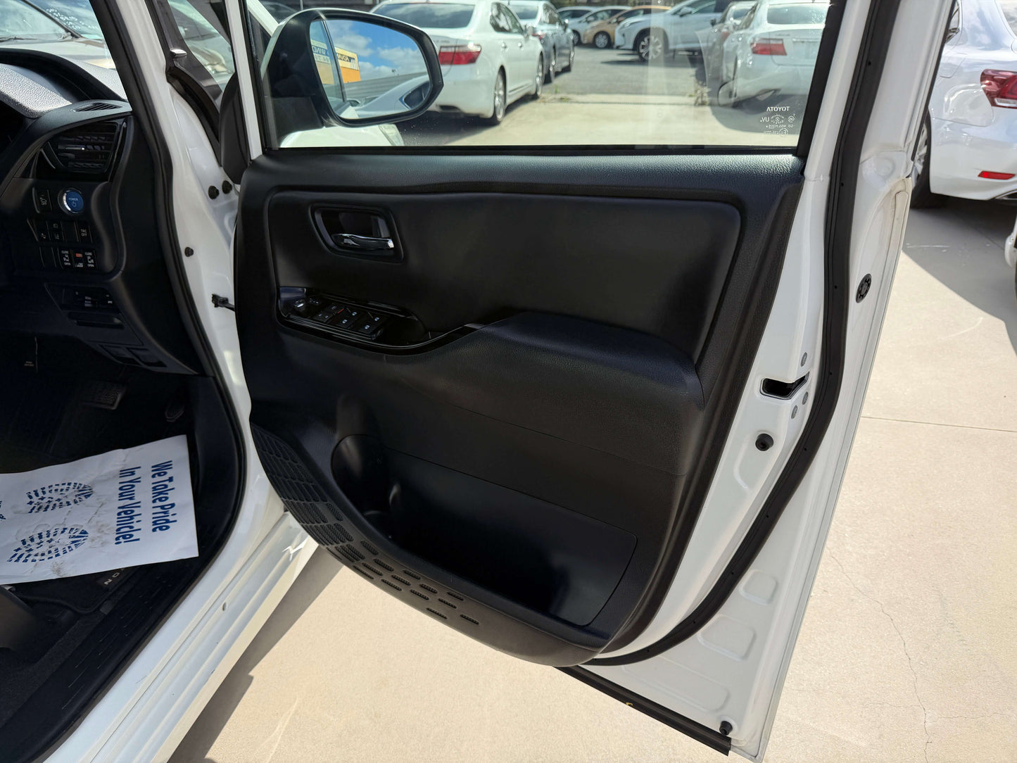 Interior view of the door panel of a 2018 Toyota Noah 1.8L Hybrid showing controls and design.