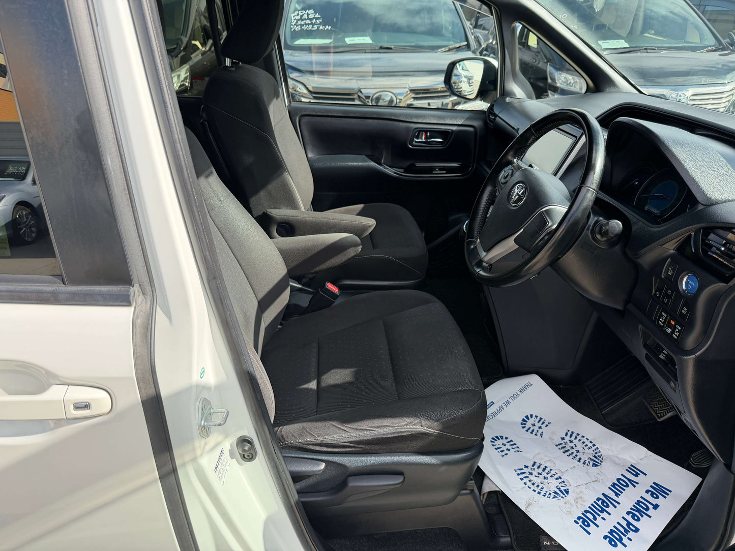 Interior view of a 2018 Toyota Noah 1.8L Hybrid G Premium Edition 7 seater showing front seats and dashboard.
