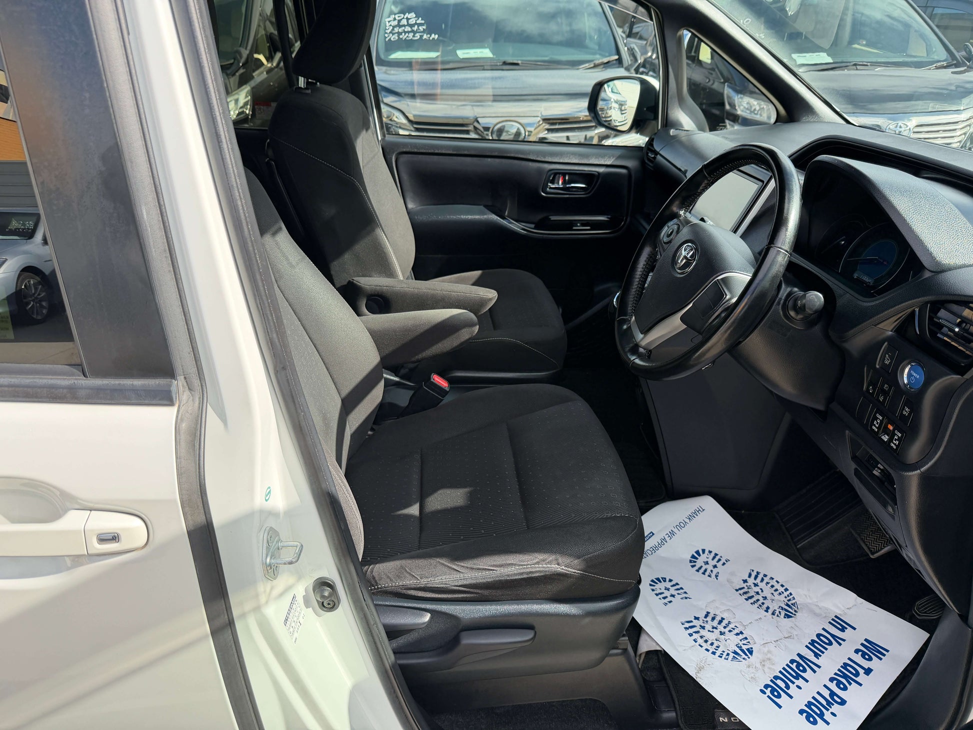 Interior view of a 2018 Toyota Noah 1.8L Hybrid G Premium Edition 7 seater showing front seats and dashboard.