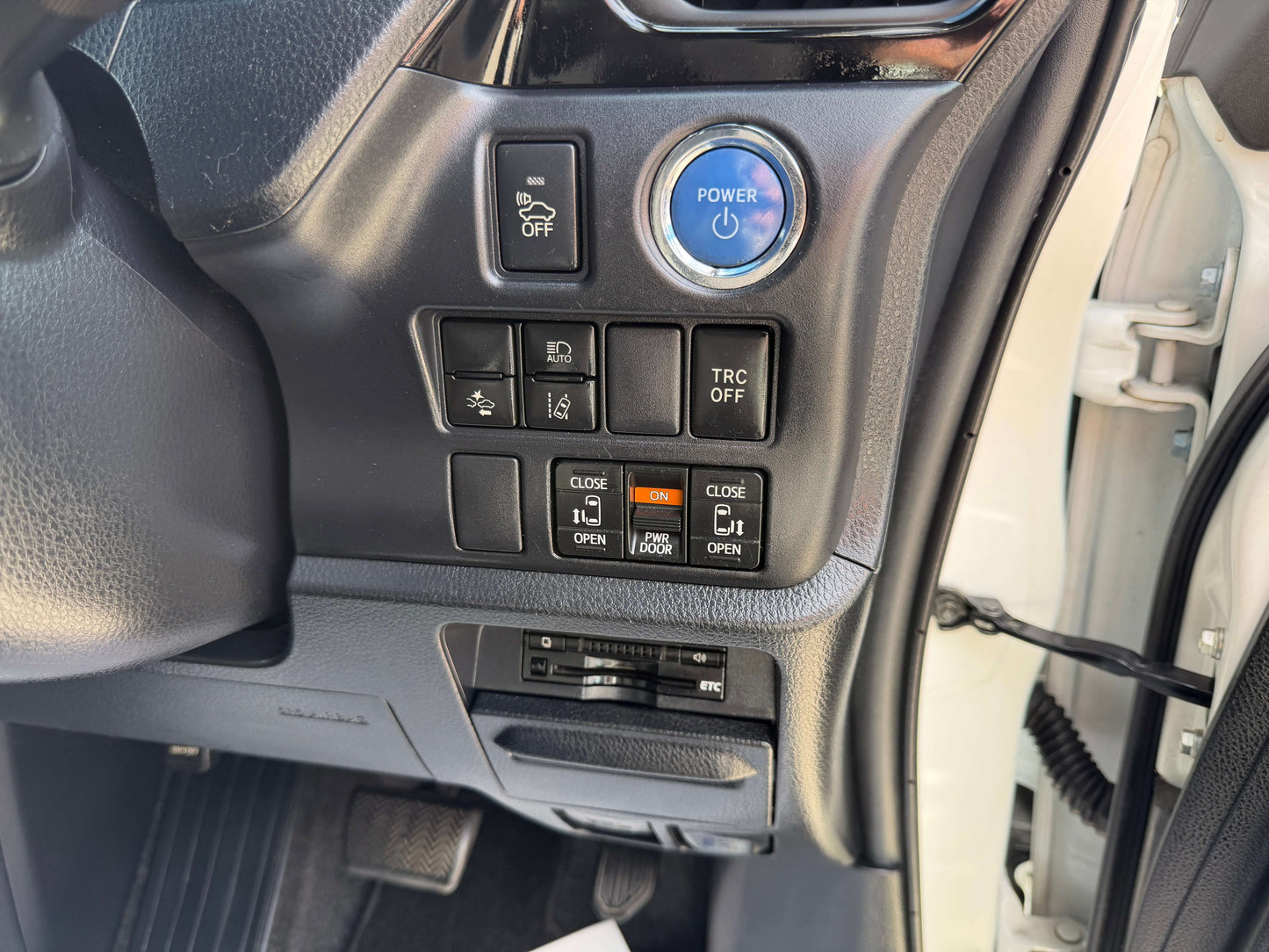 Interior dashboard controls of a 2018 Toyota Noah 1.8L Hybrid, featuring power button and various settings.