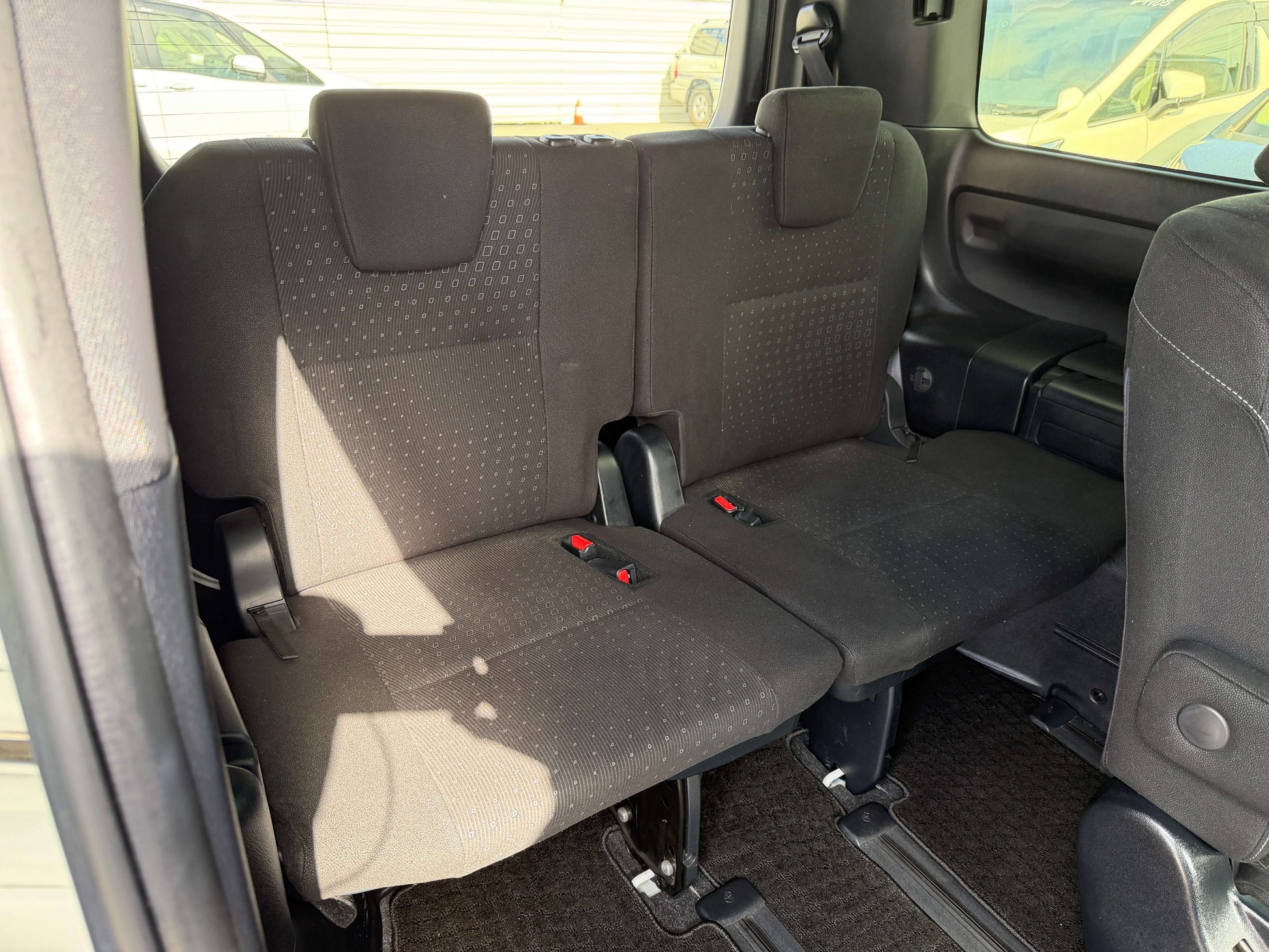 Interior view of the rear seating in a 2018 Toyota Noah 1.8L Hybrid with spacious 7 seat configuration.