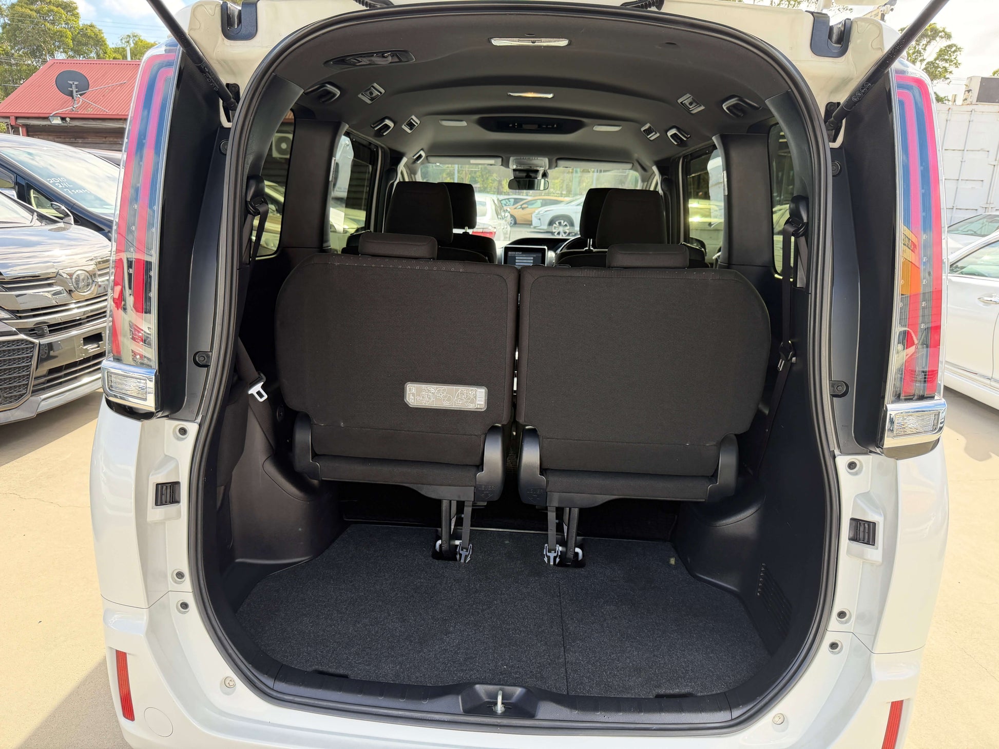 Interior view of the 2018 Toyota Noah 1.8L Hybrid G Premium Edition showing rear passenger seating and cargo space.