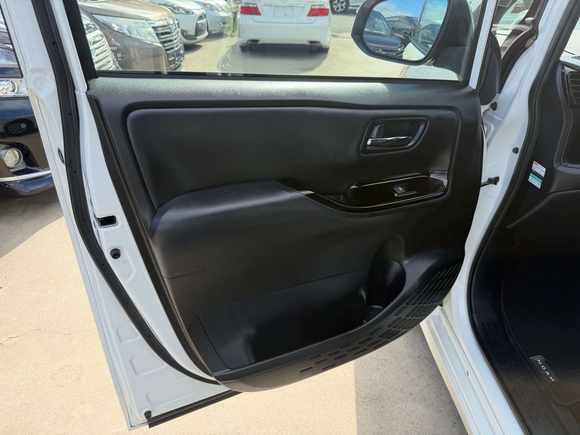 Interior view of the 2018 Toyota Noah 1.8L Hybrid door, showcasing black door panel design.