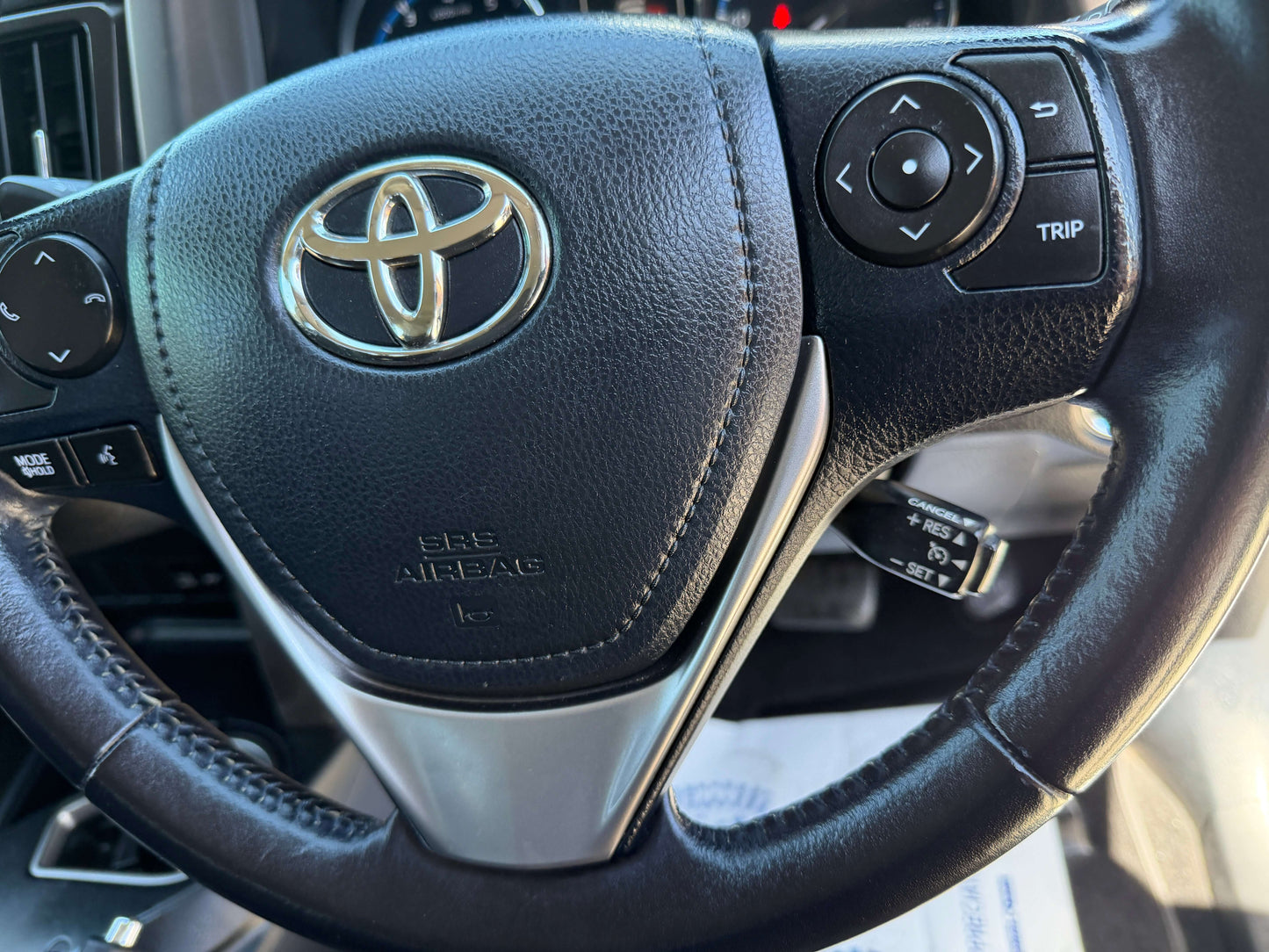 2016 Toyota RAV4 steering wheel with controls and logo, showing the interior features of the vehicle.