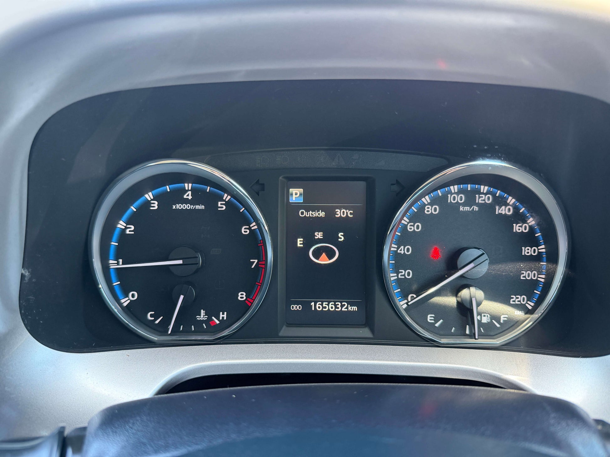 Dashboard of a 2016 Toyota RAV4 showing speedometer, fuel gauge, and odometer reading 165632 km.