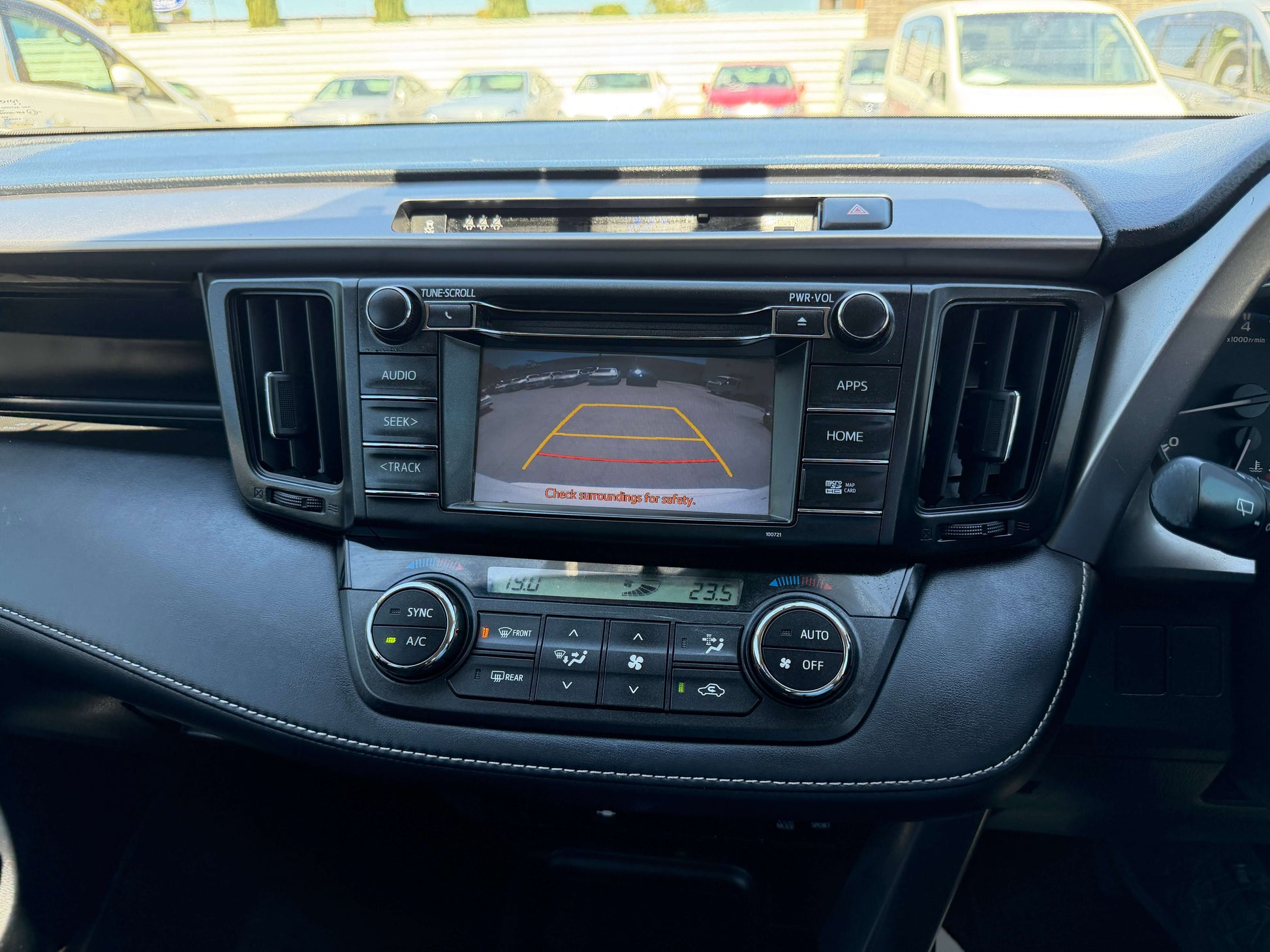 Interior view of a 2016 Toyota RAV4 dashboard showing the rearview camera display and controls.